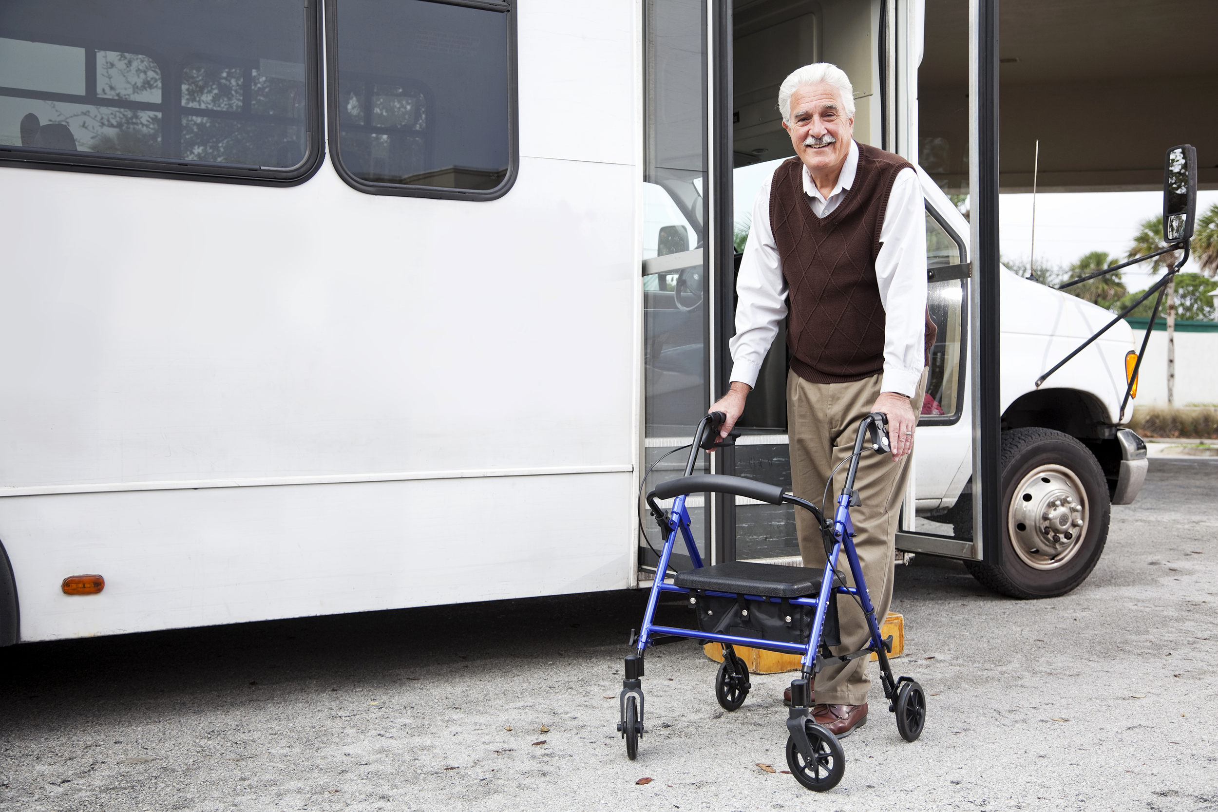 Senior man with a walker getting out of a shuttle bus