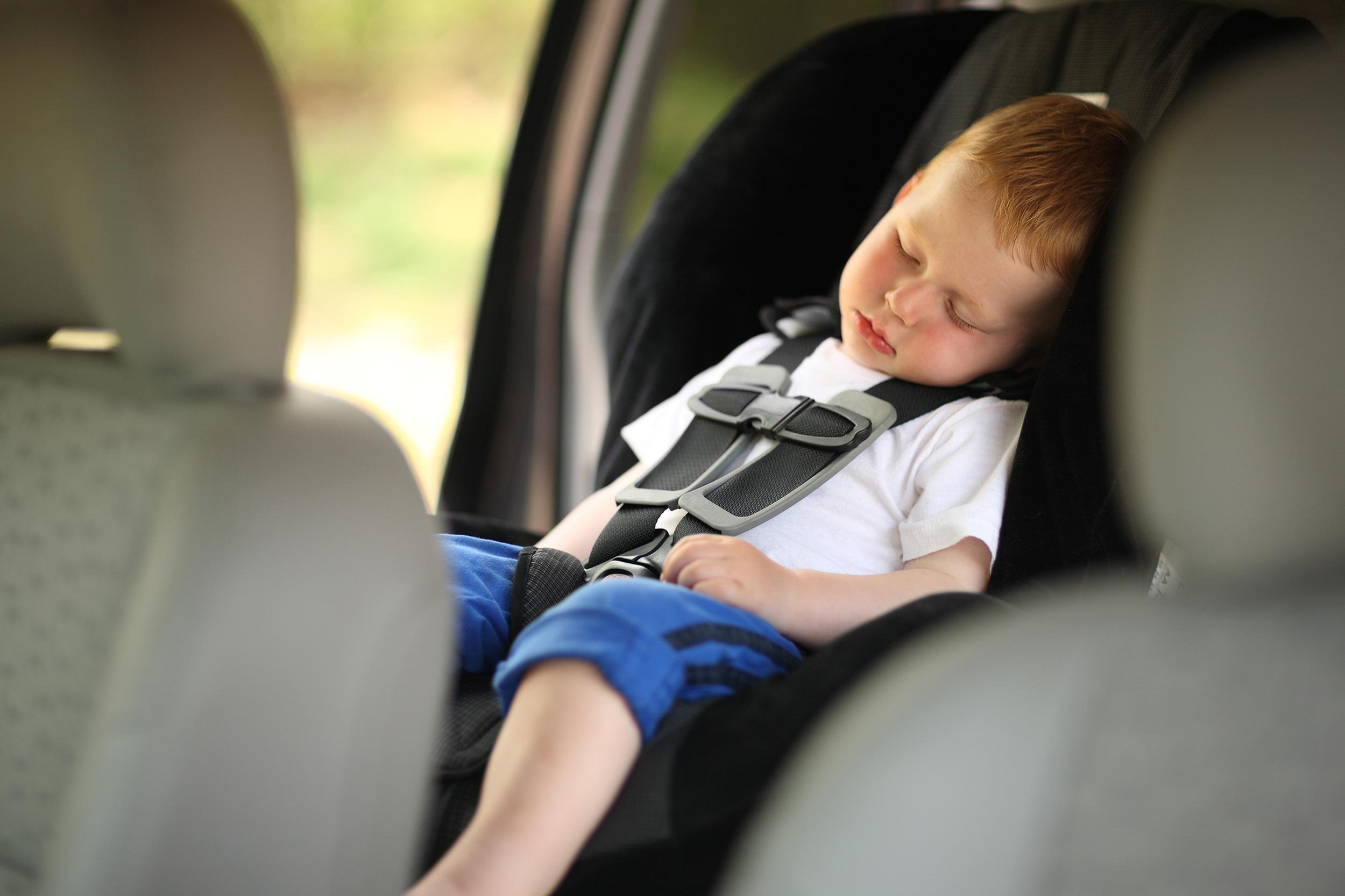 boy sleeping in child car seat
