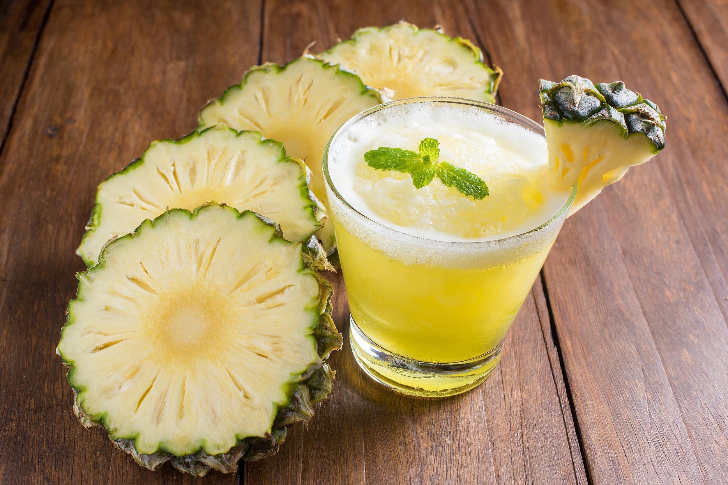 pineapple juice cocktail with pineapple slices on wooden table