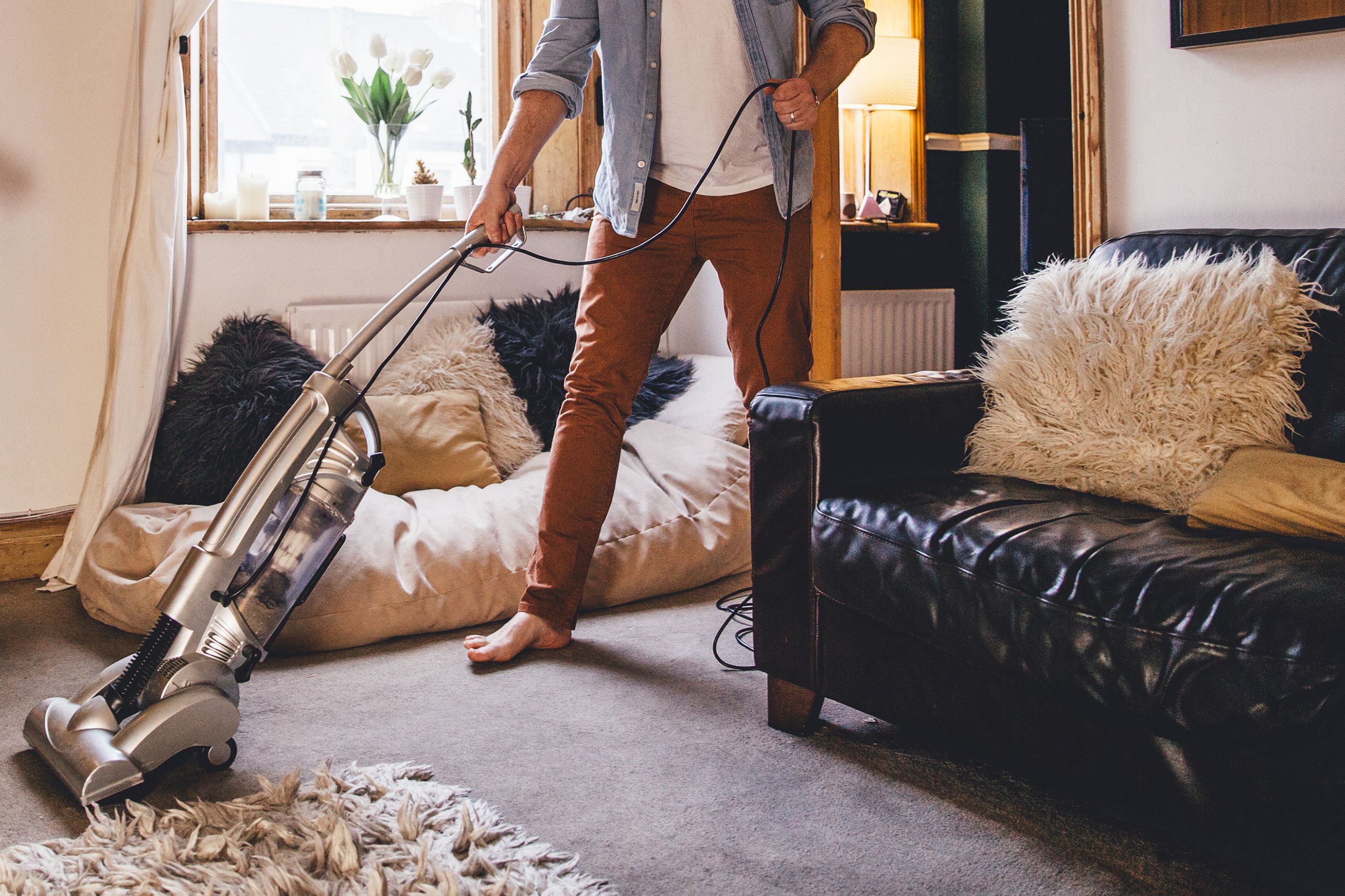 man vacuuming in apartment