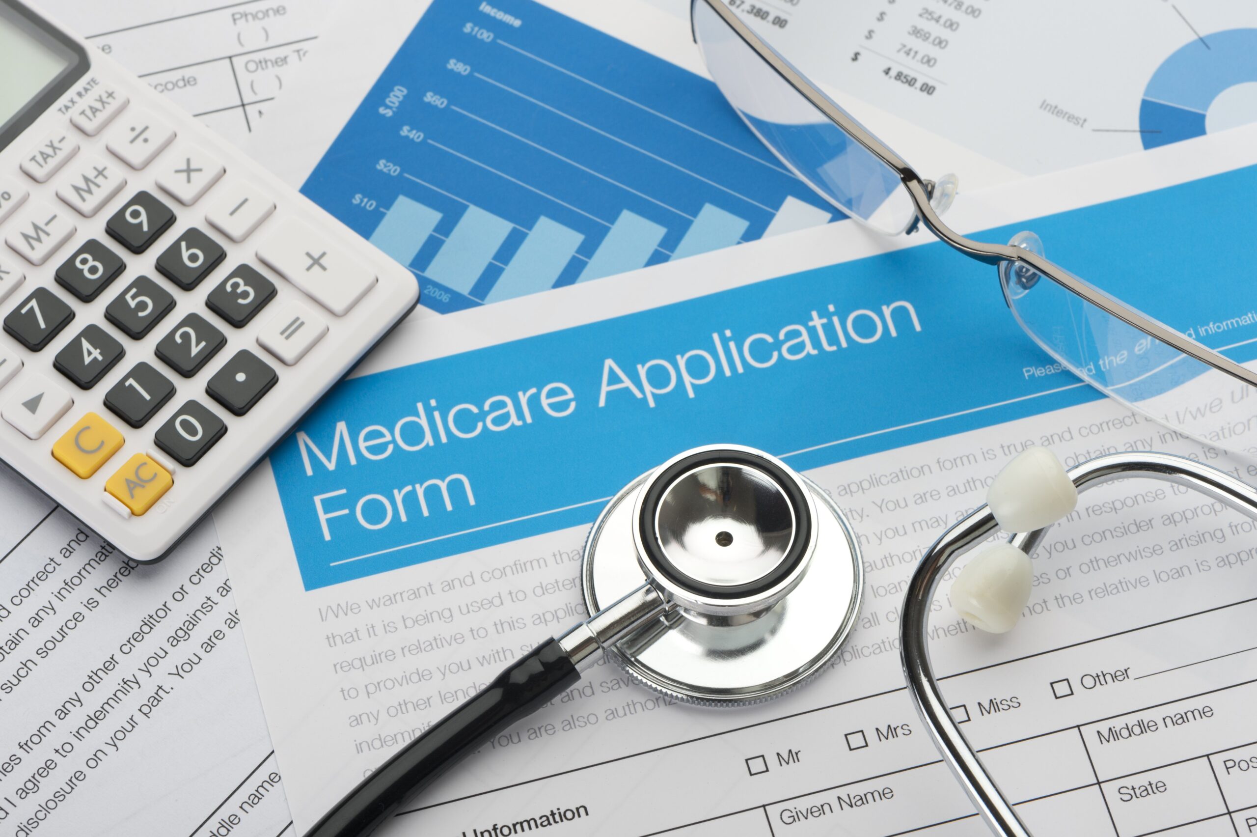 table with medicare application forms and a stethoscope on top