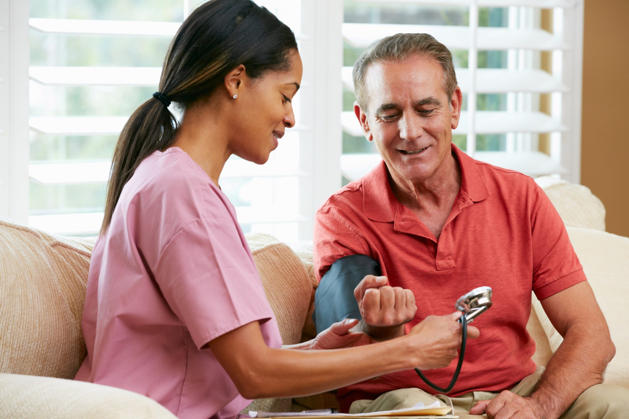 nurse checking blood pressure of an elderly man