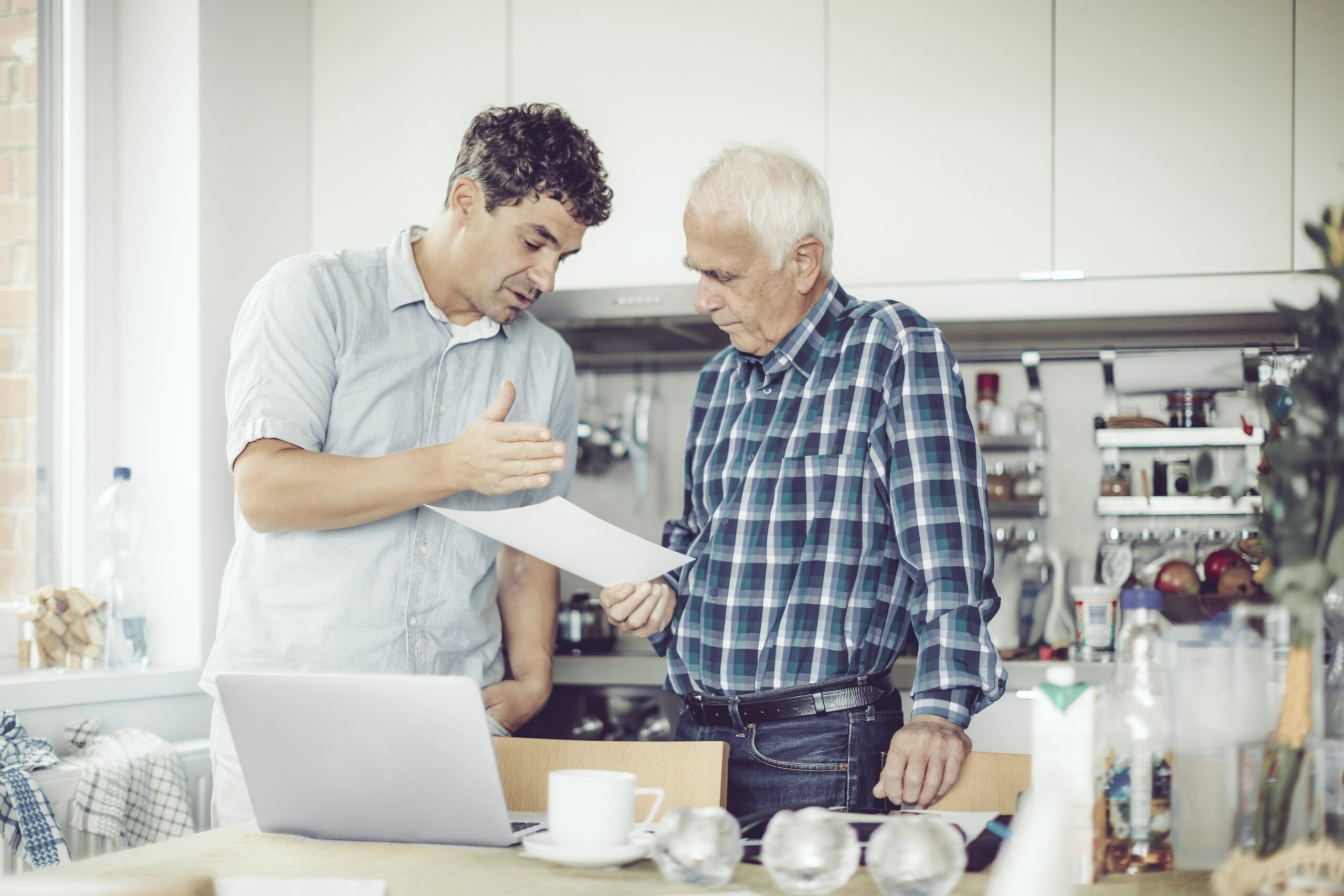Son reviewing paperwork with elderly father