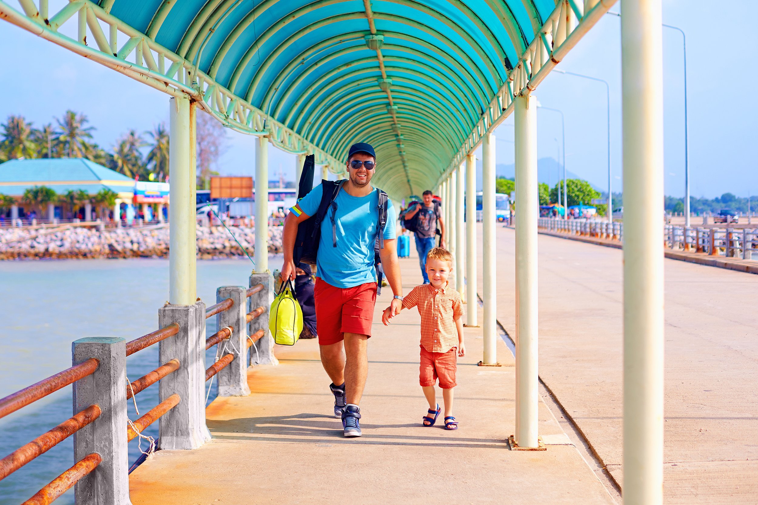 happy father and son are going to board a ship at the pier station