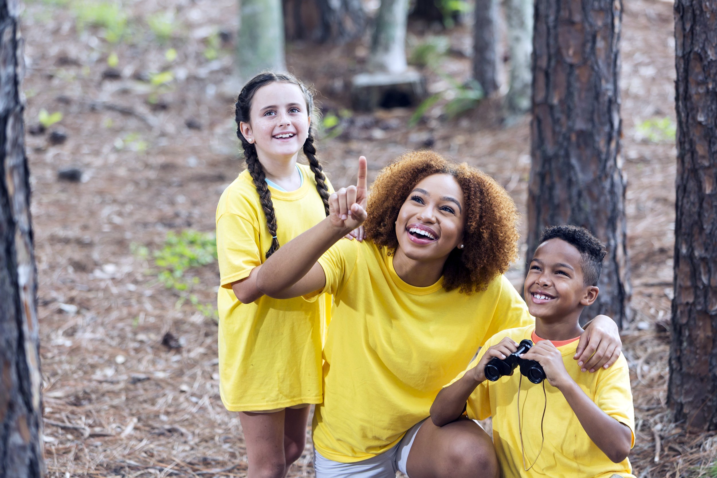 camp adult with two kids looking at nature