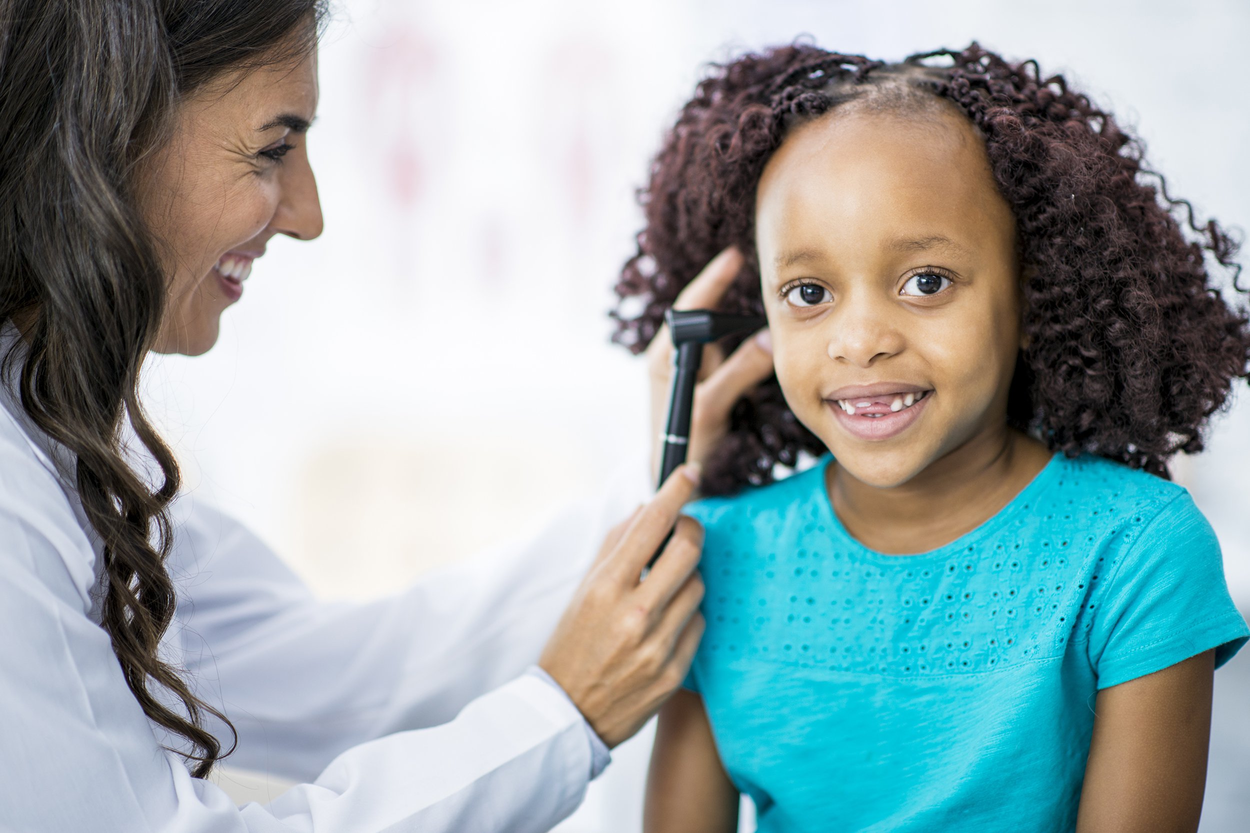 doctor checking ear of little girl