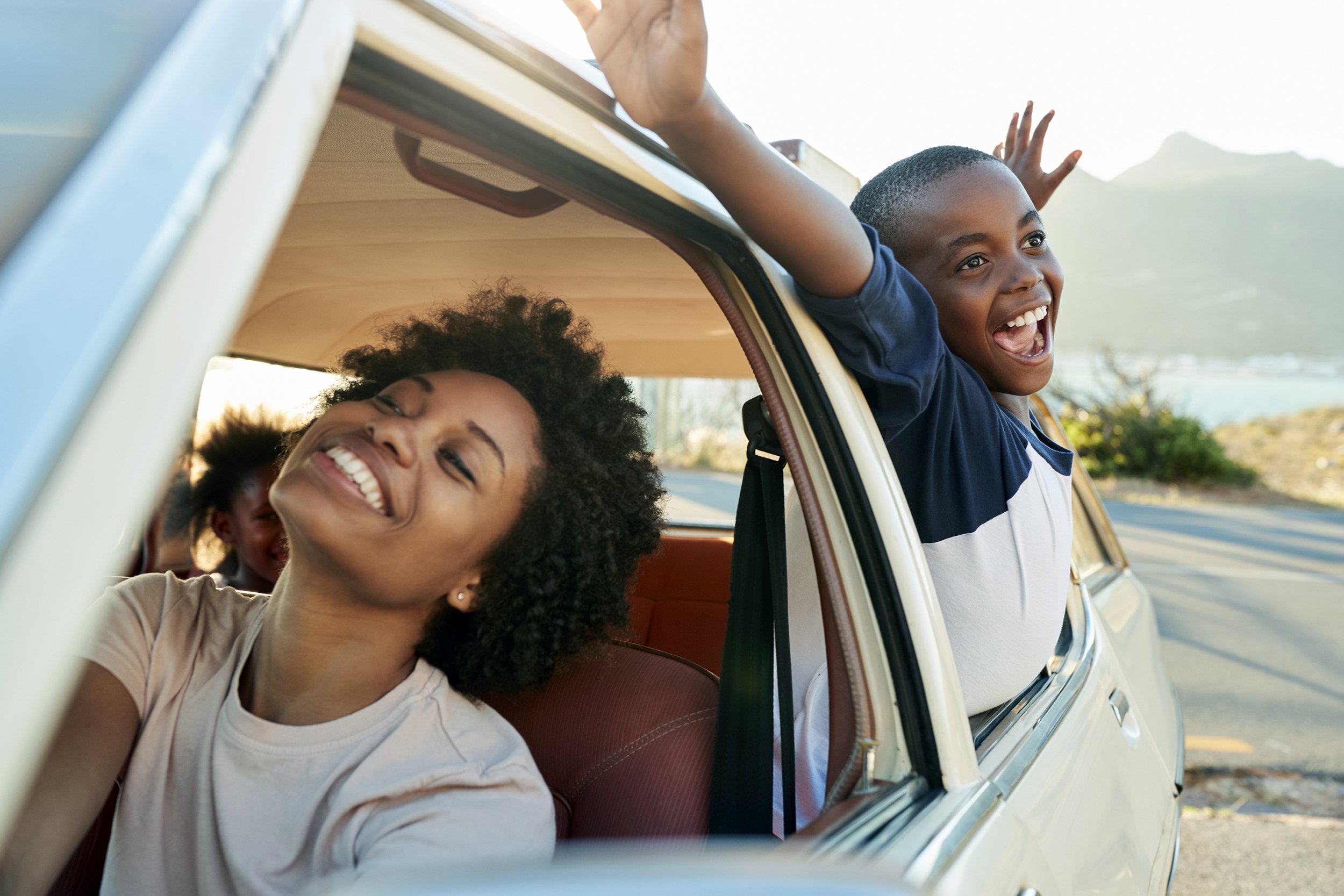 mother and children relaxing in car during road trip
