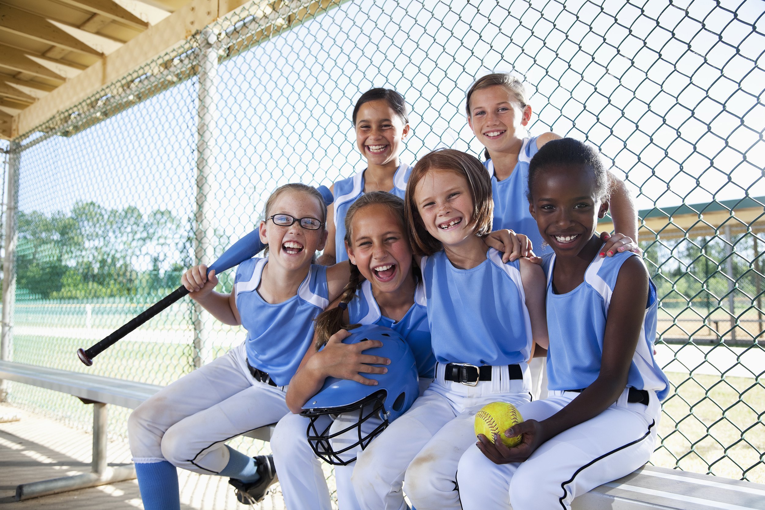 girls softball team sitting in dugout