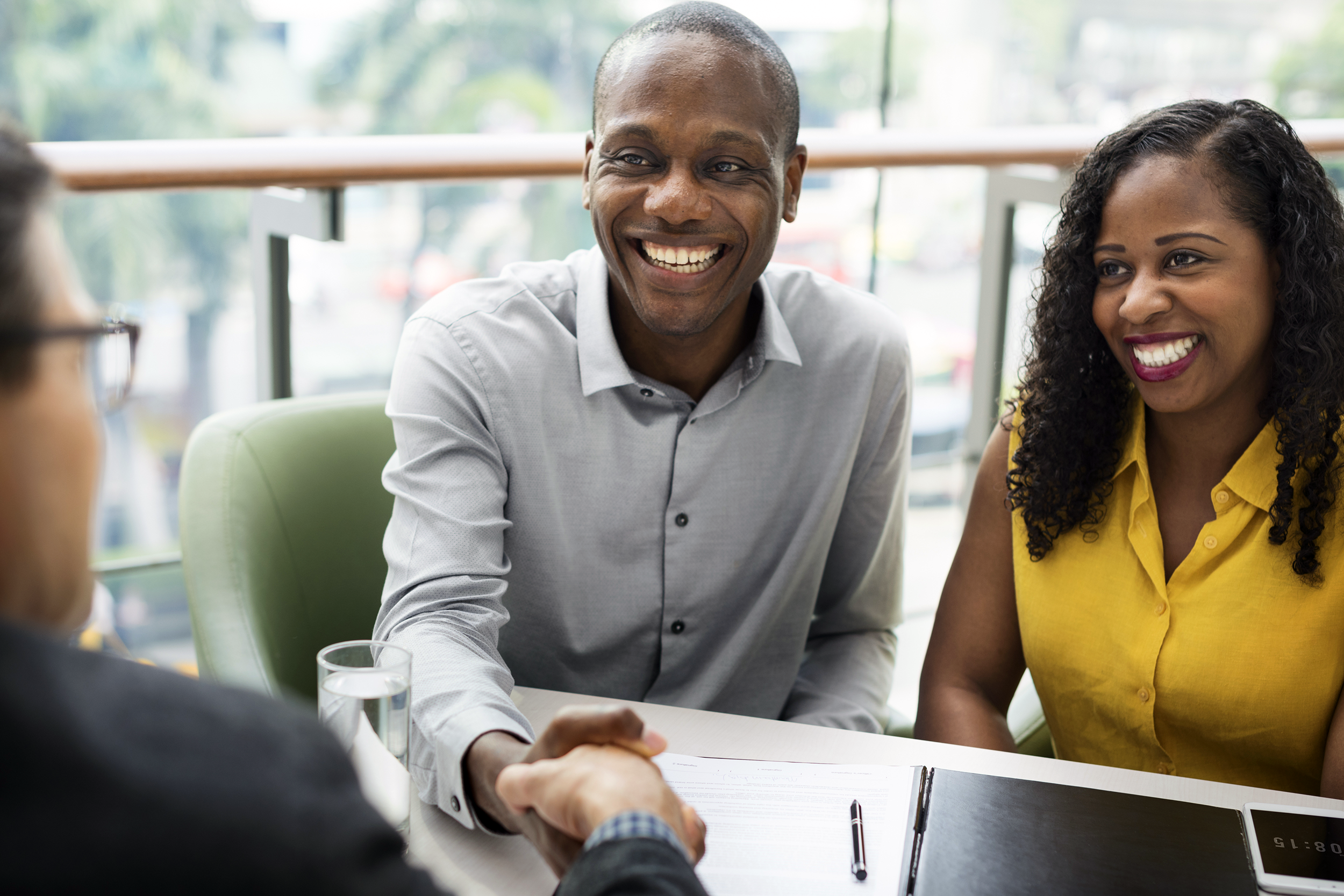 Happy couple speaking with a financial adviser