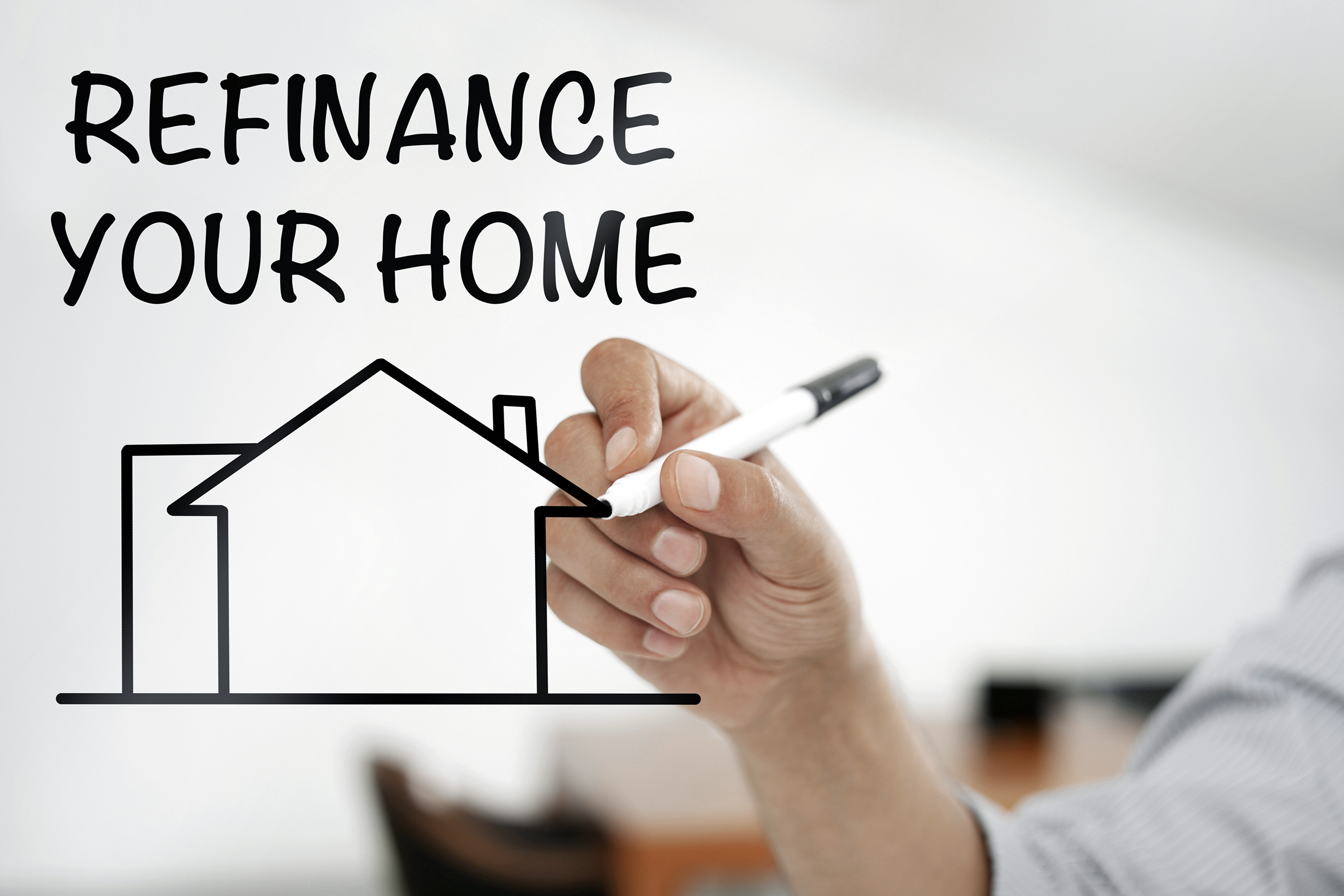 Writing 'Refinancing Your Home' with a dry erase marker
