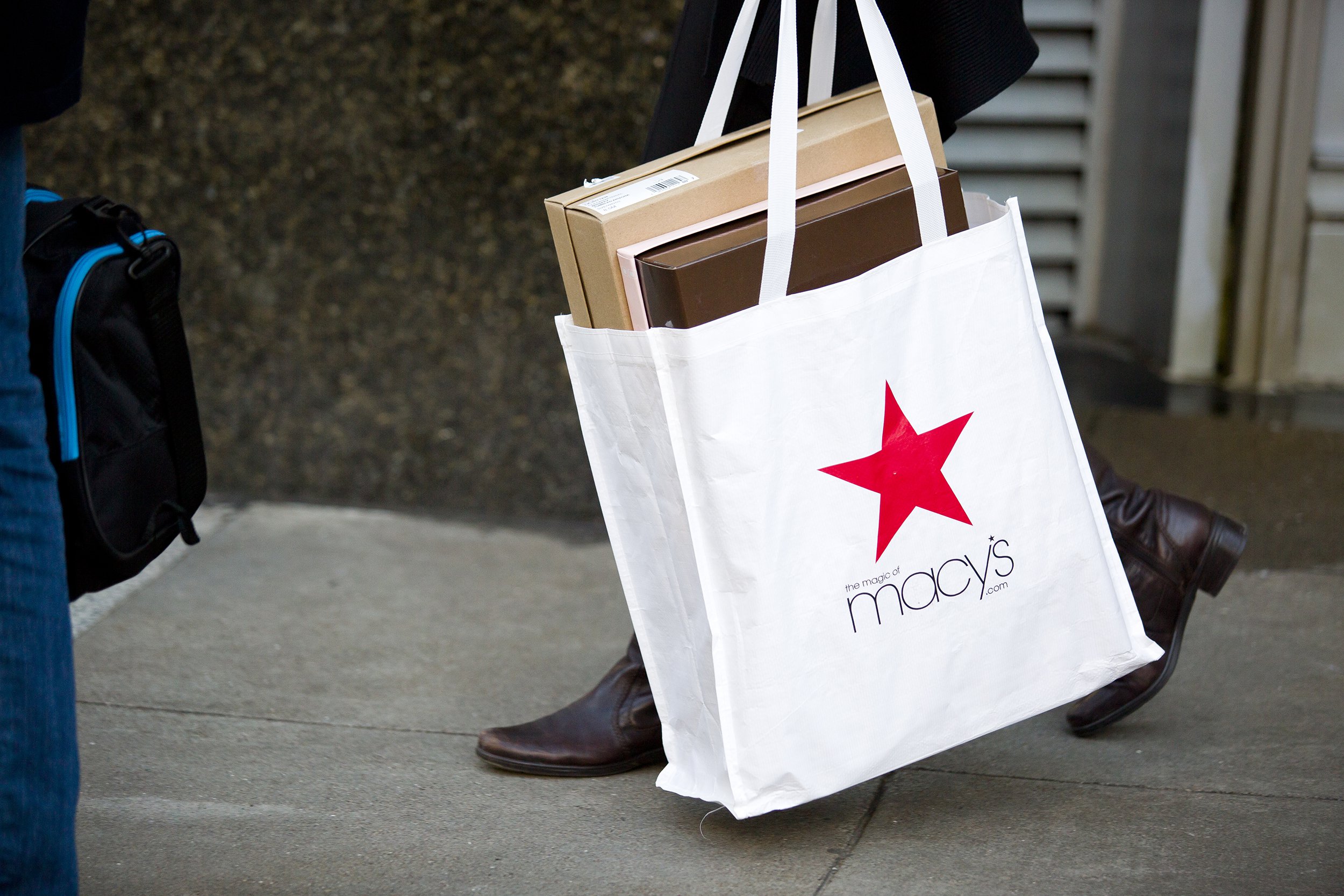 shoes in Macy's bag with shopper walking on street