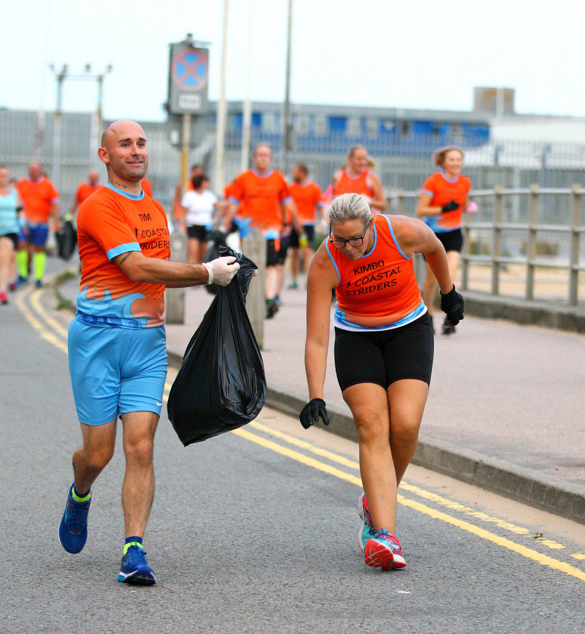 man and woman plogging with a group