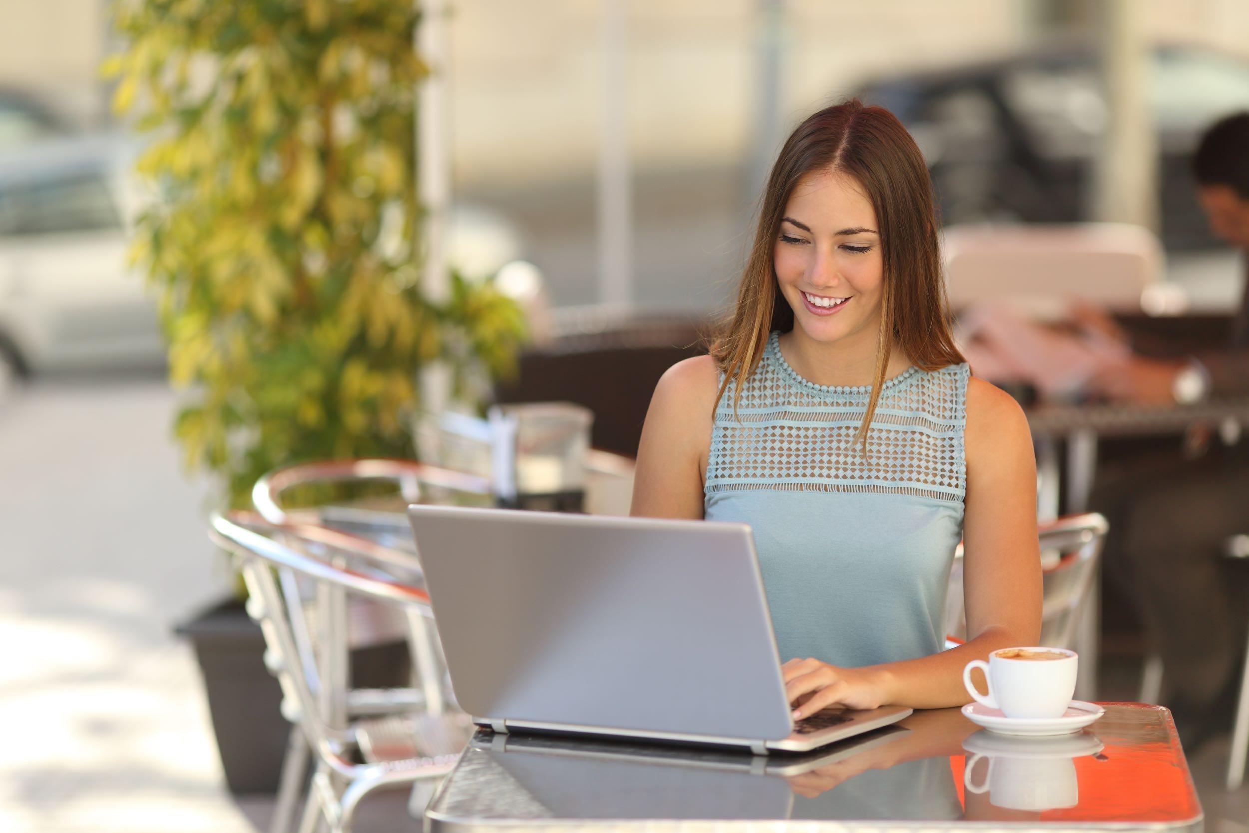 teen on laptop at cafe