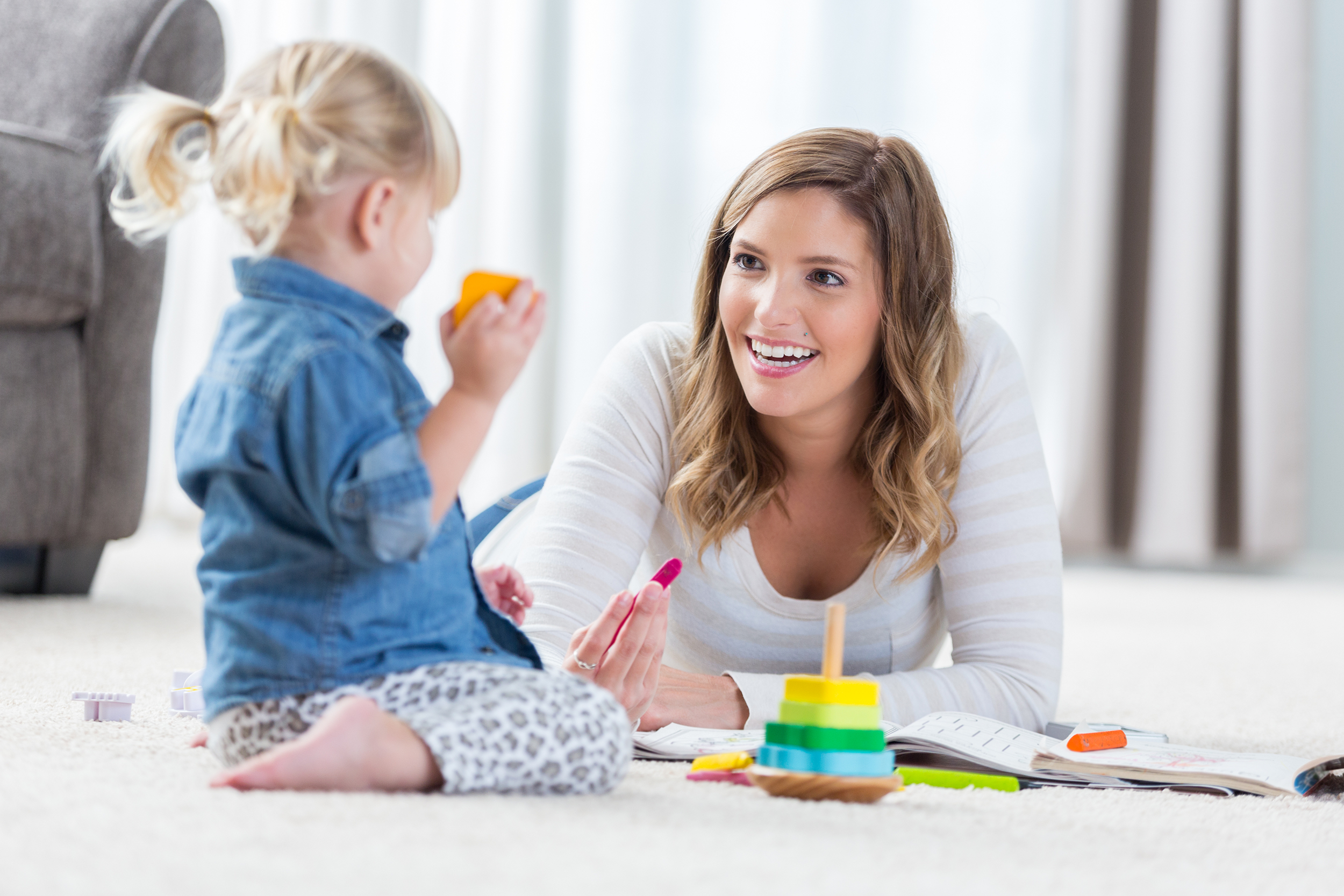Au Pair playing with a little girl and her toys