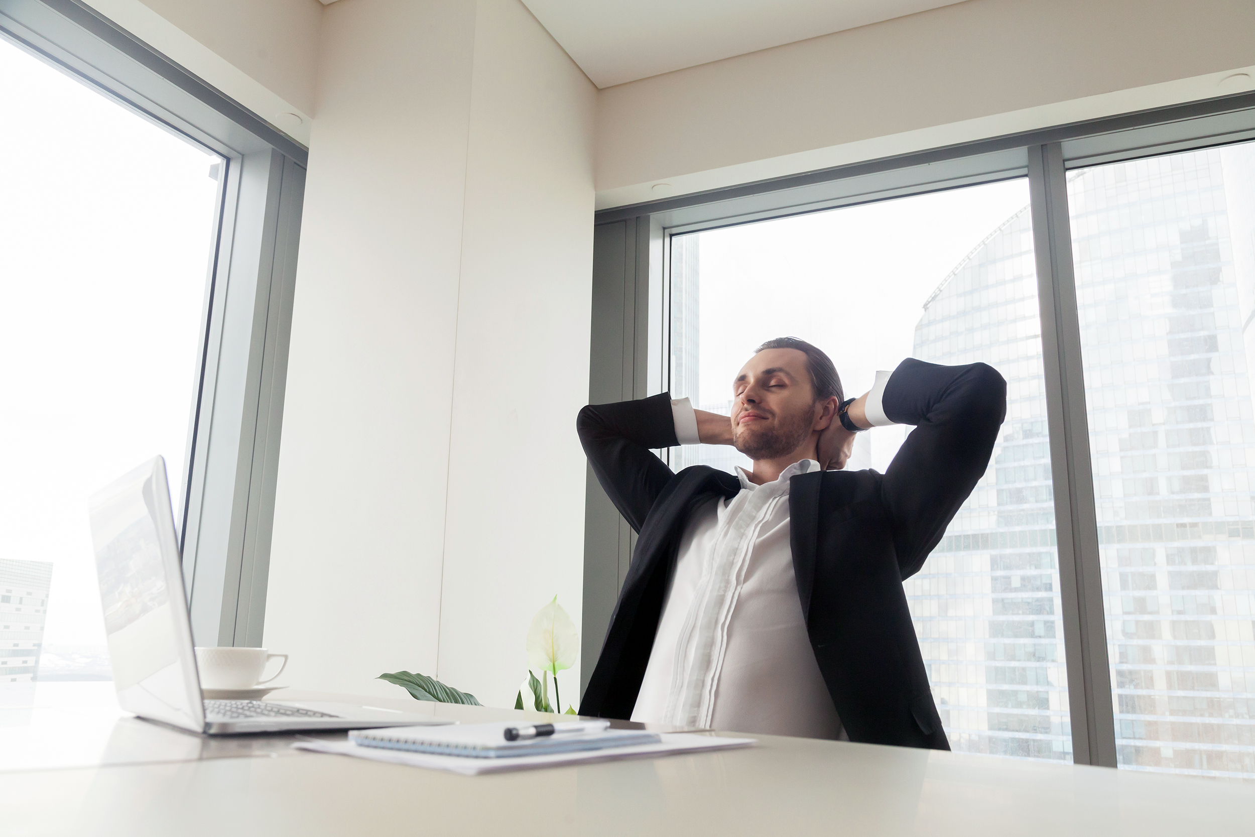 Man relaxing and sitting back in chair at work