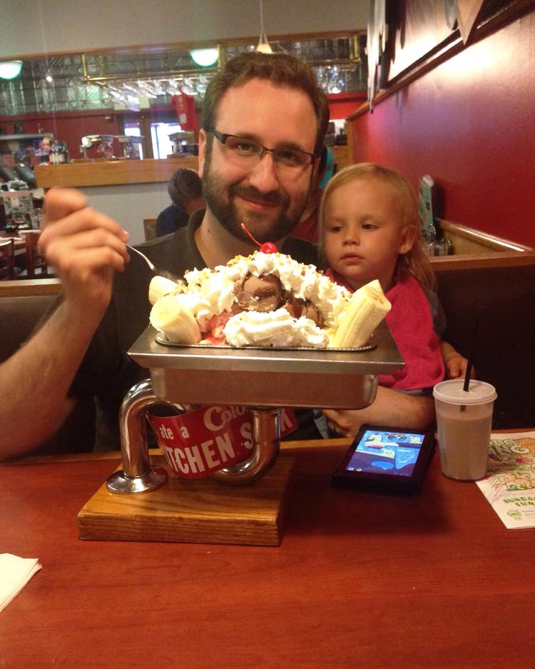 Father and daughter eating a banana split at Colonial Cafe