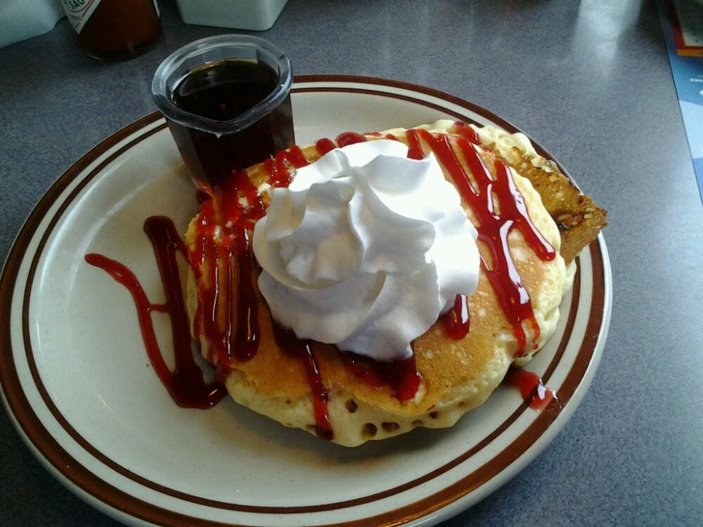 Pancakes with whipped cream and berry sauce
