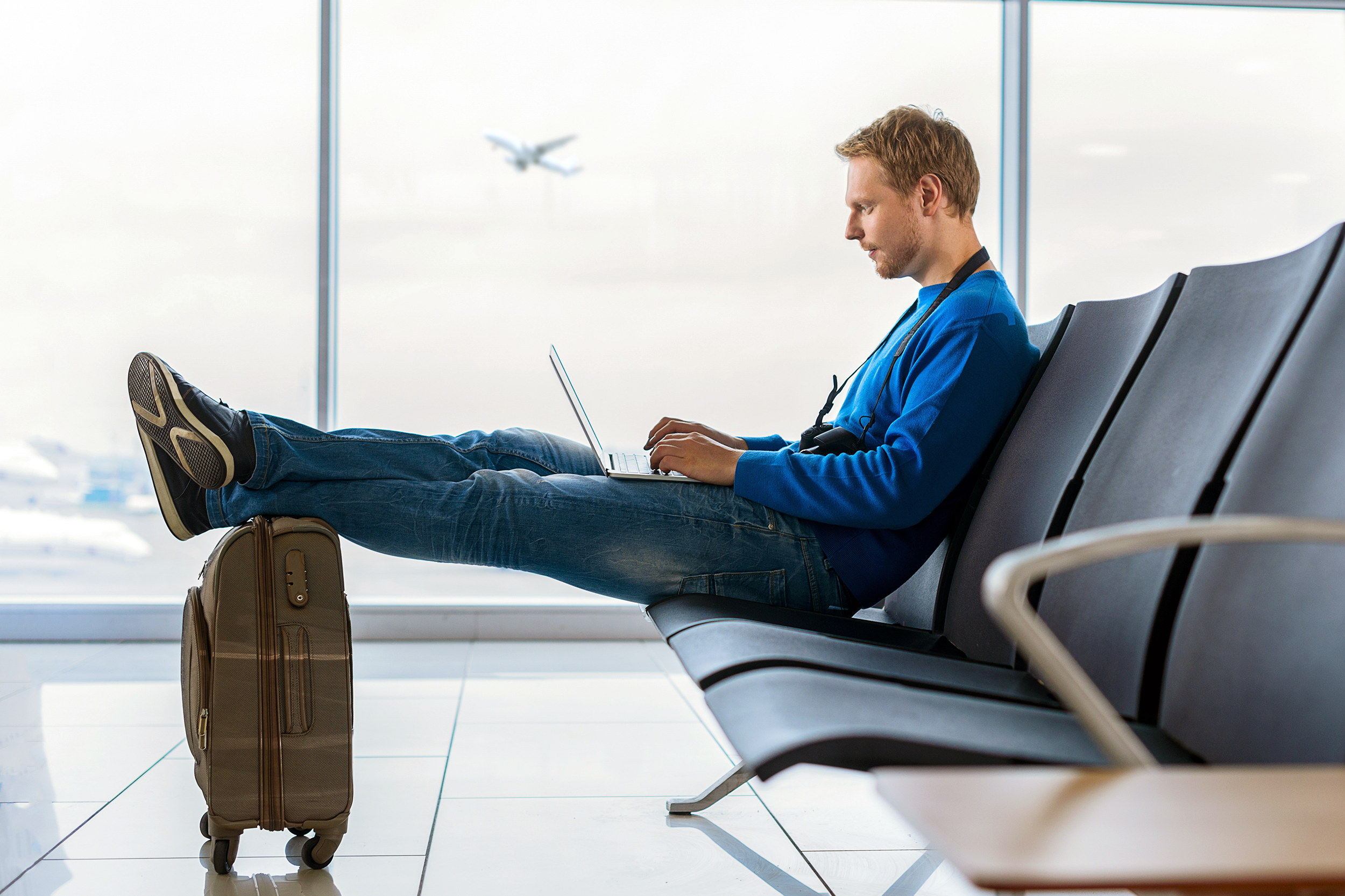 Man working on his laptop in the airport