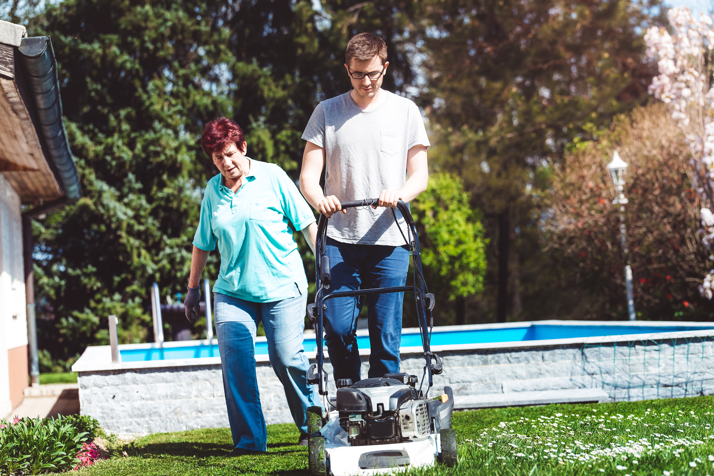 Man mowing a lawn for an older woman