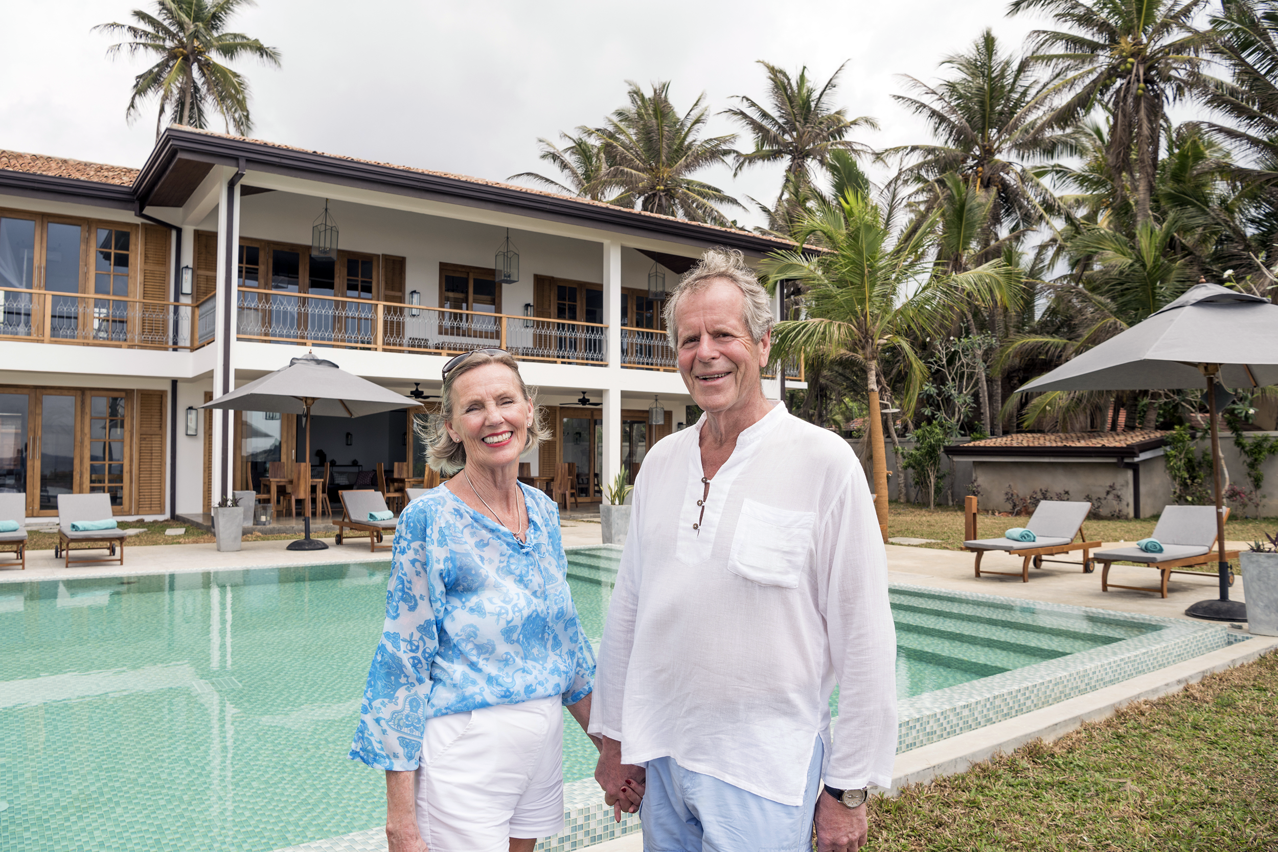Happy older couple standing outside of vacation home
