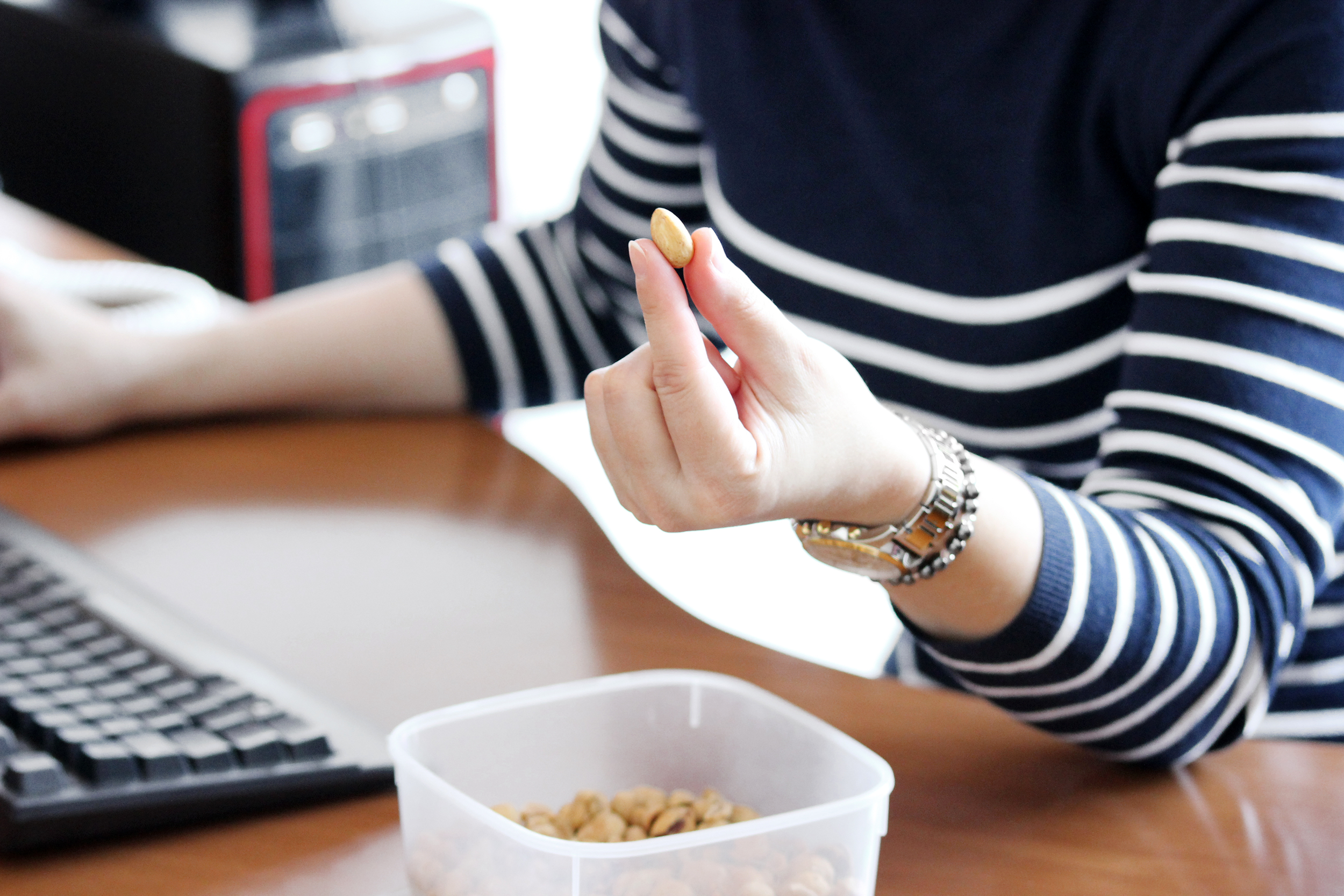 Woman having a snack of nuts at her desk