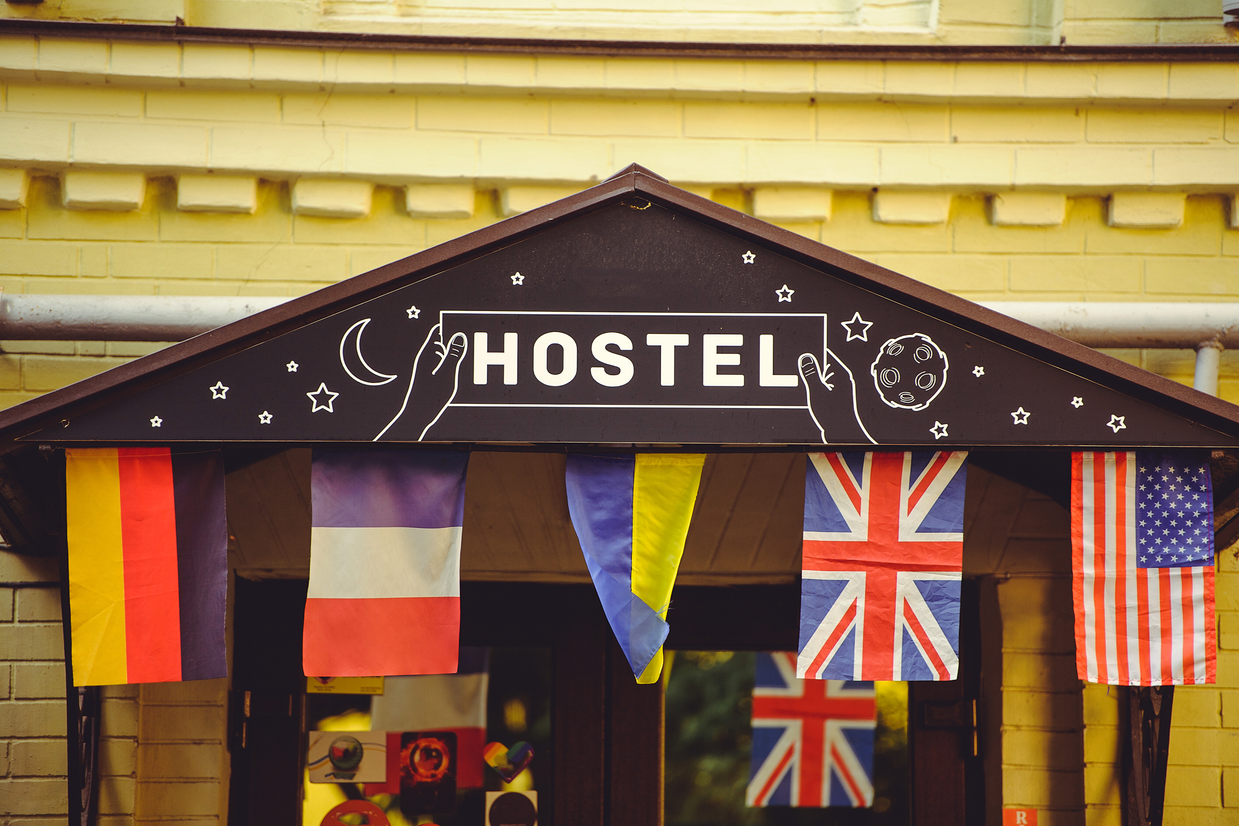 Front view of a hostel with many countries' flags hanging outside