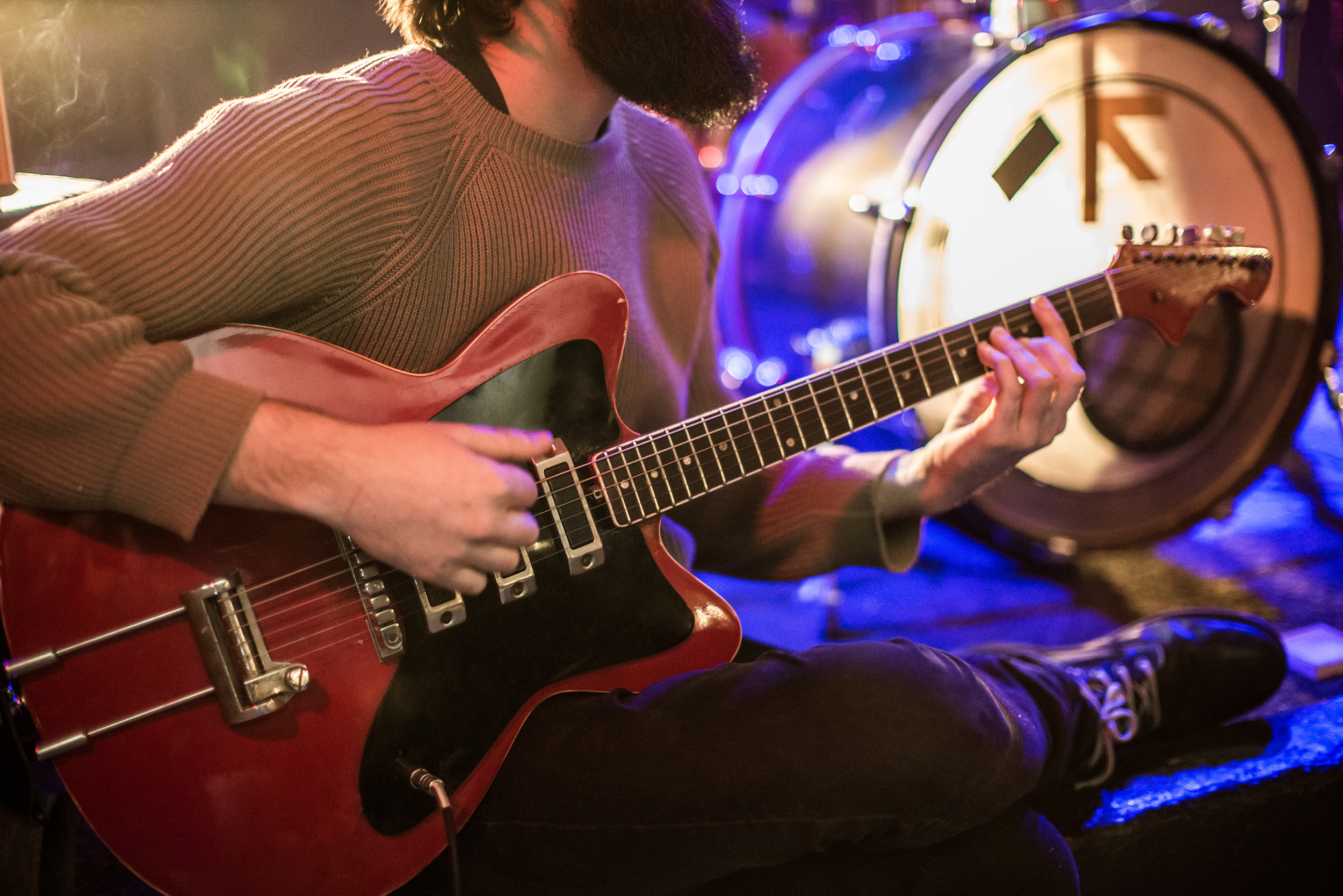Closeup of man playing an electric guitar during a concert