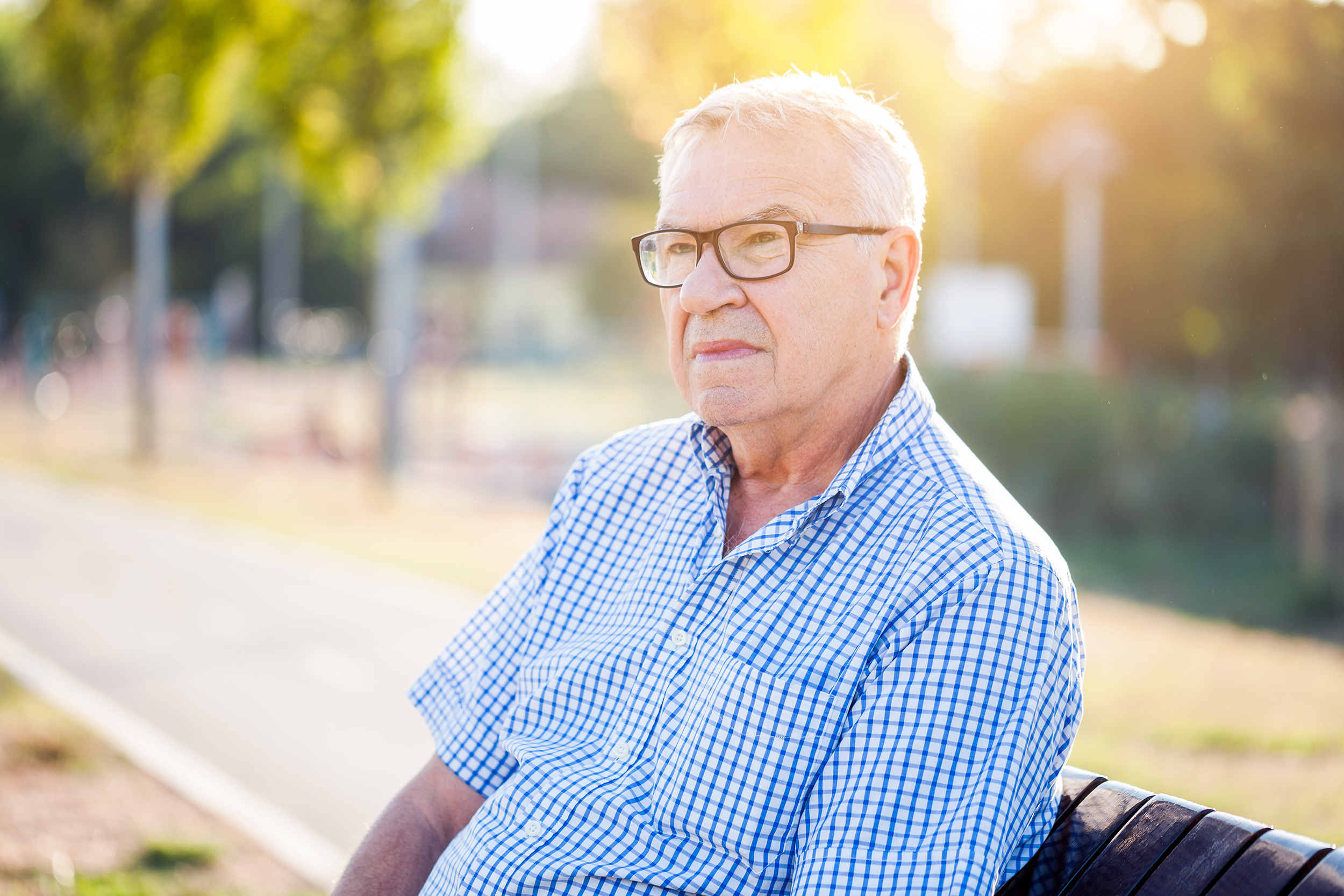 Older man sitting on a bench outside