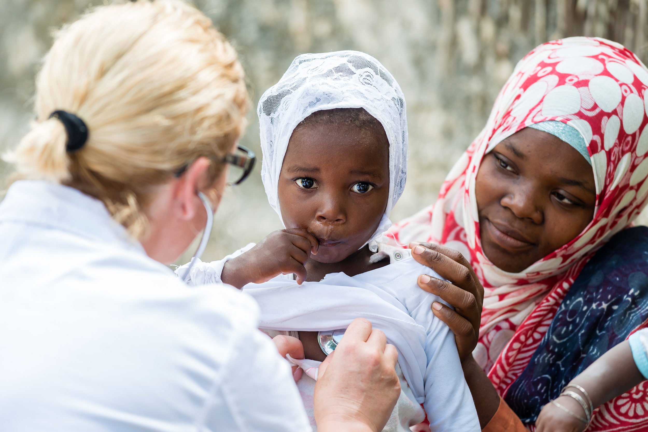 Nurse assisting a young child in a developing country