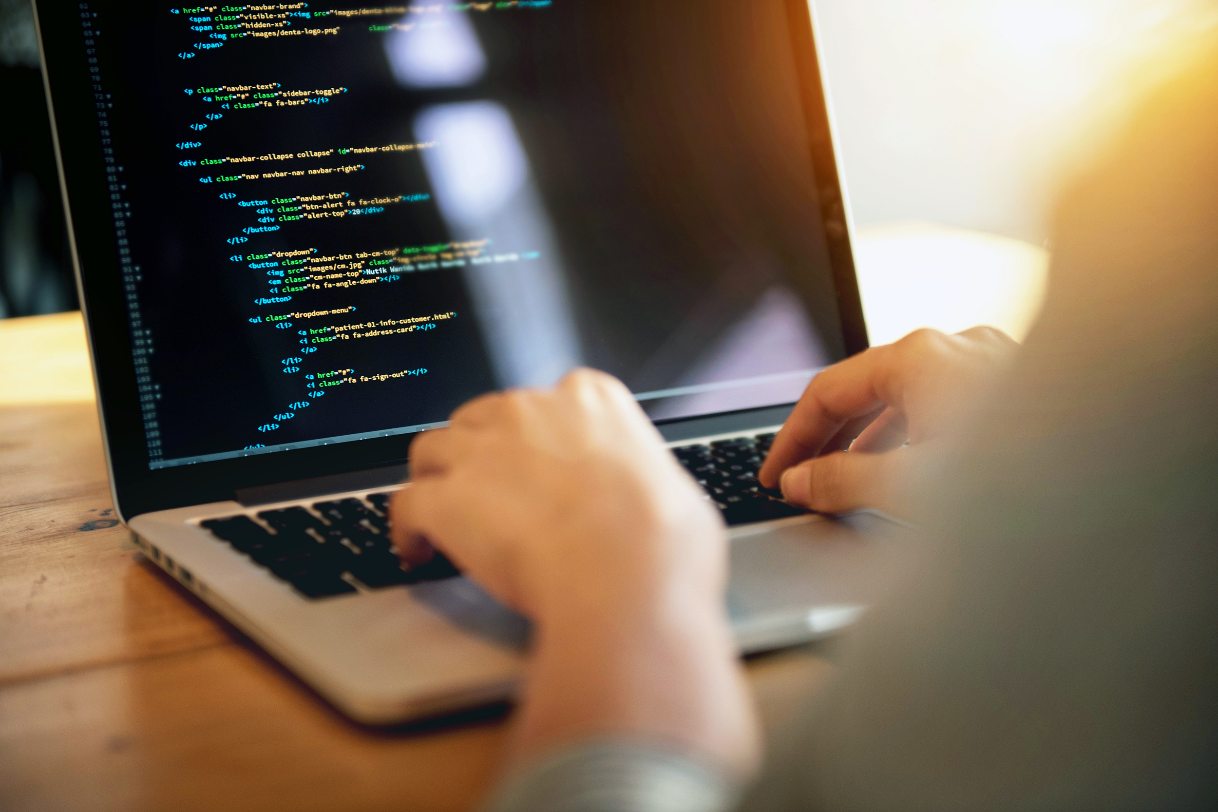 Web developer coding on a laptop