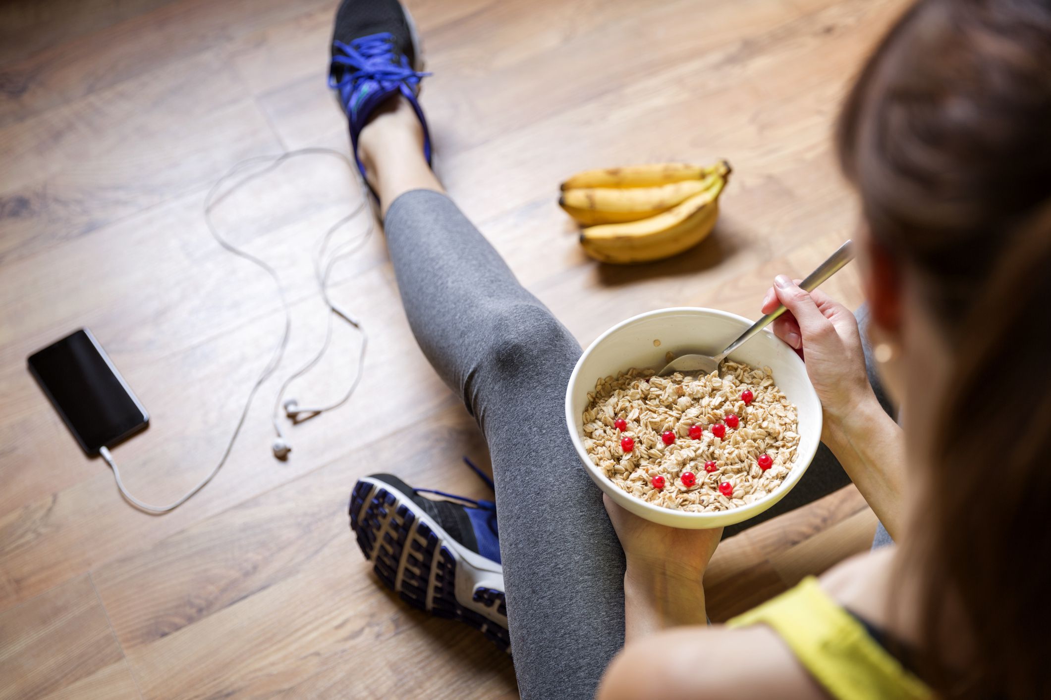 young woman eating a oatmeal with berries after a workout