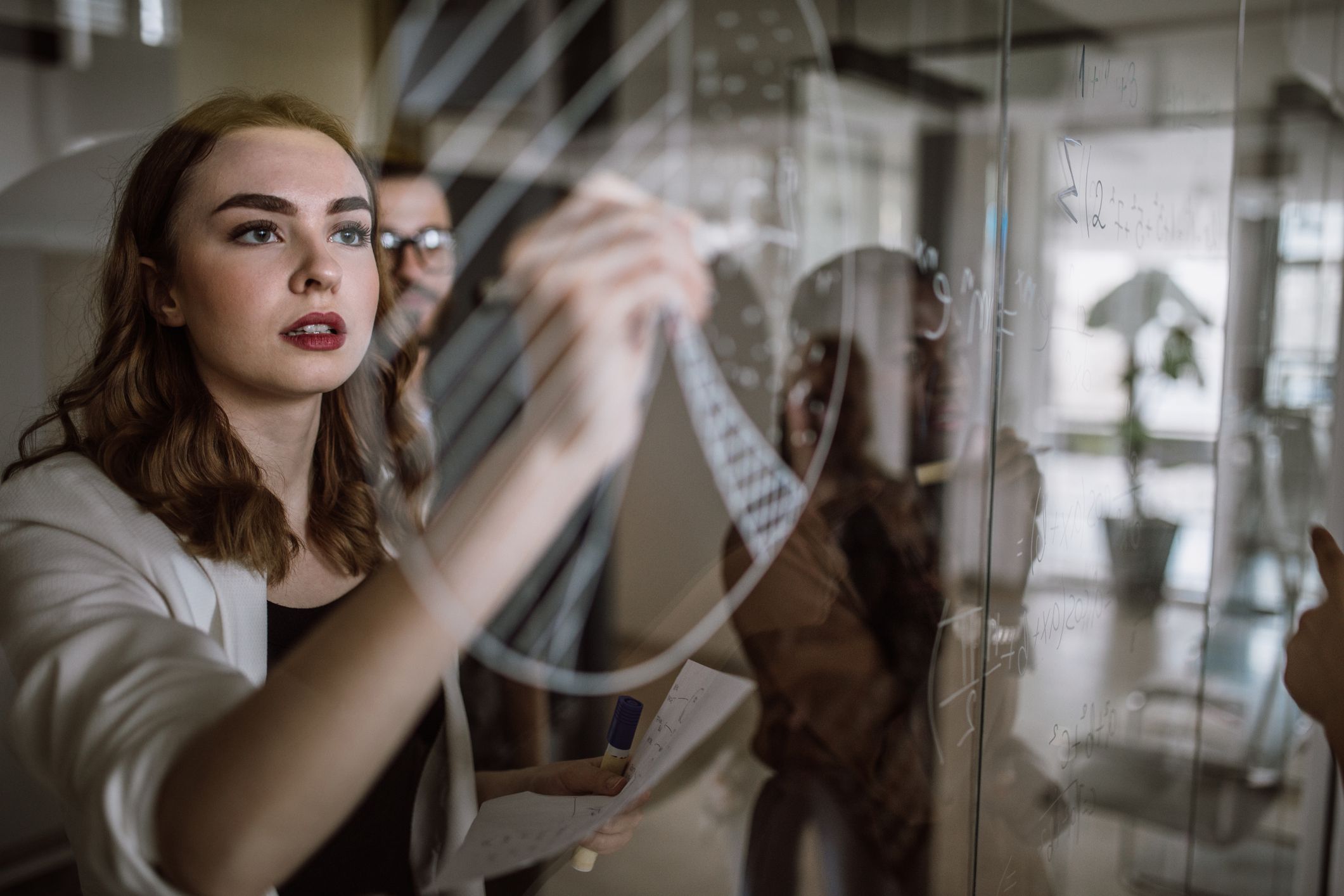 woman at work, drawing on glass board