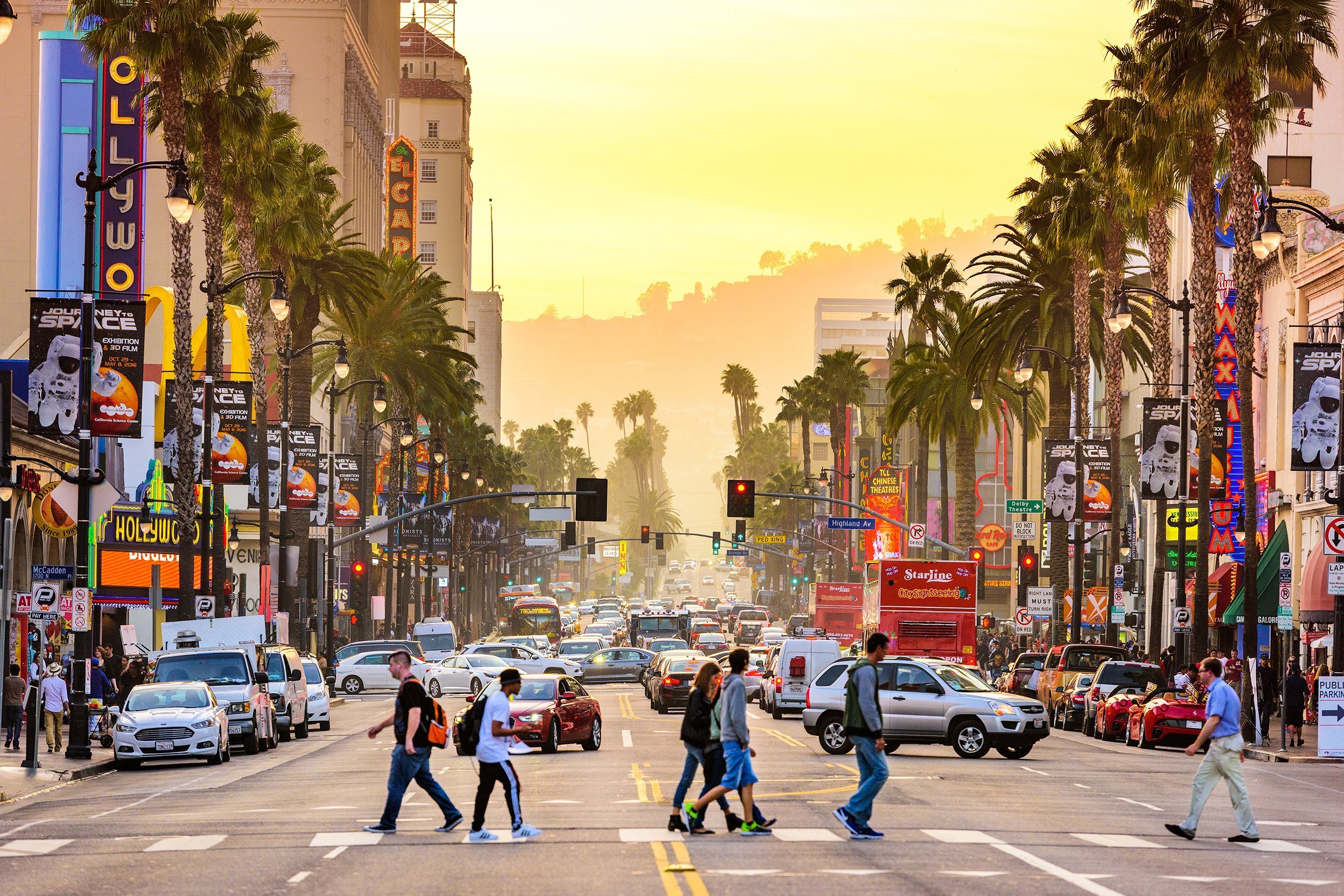 traffic and pedestrians on Hollywood Boulevard at dusk in Los Angeles