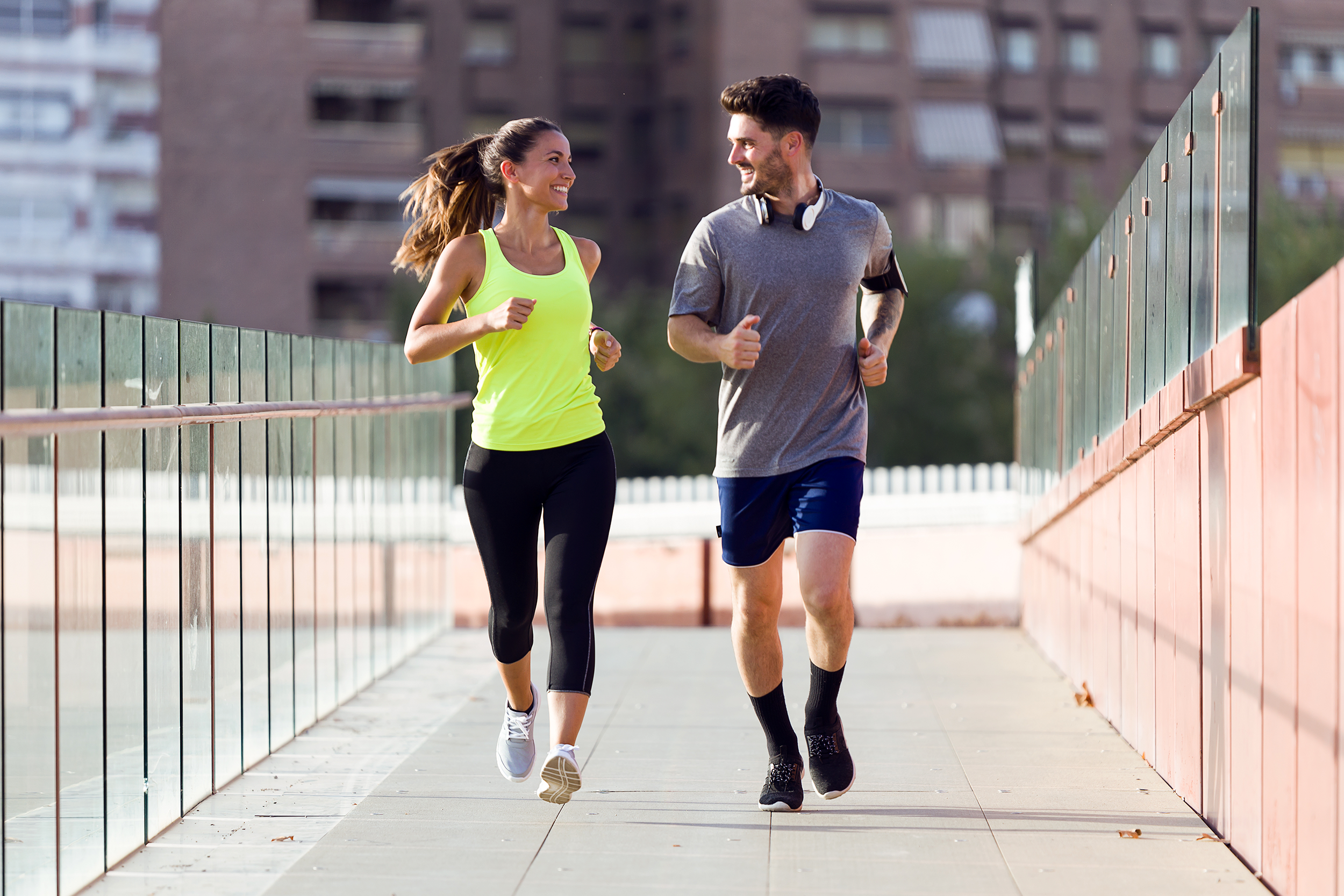 Couple jogging outside in the city wearing exercise clothes