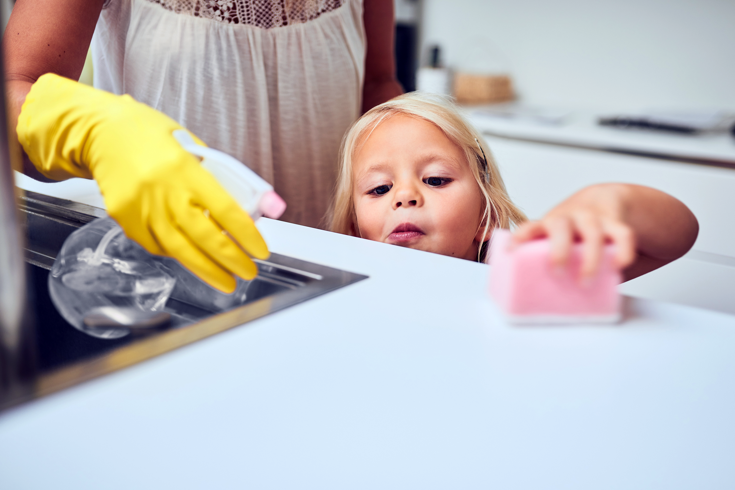 Mother and daughter cleaning the kitchen counter