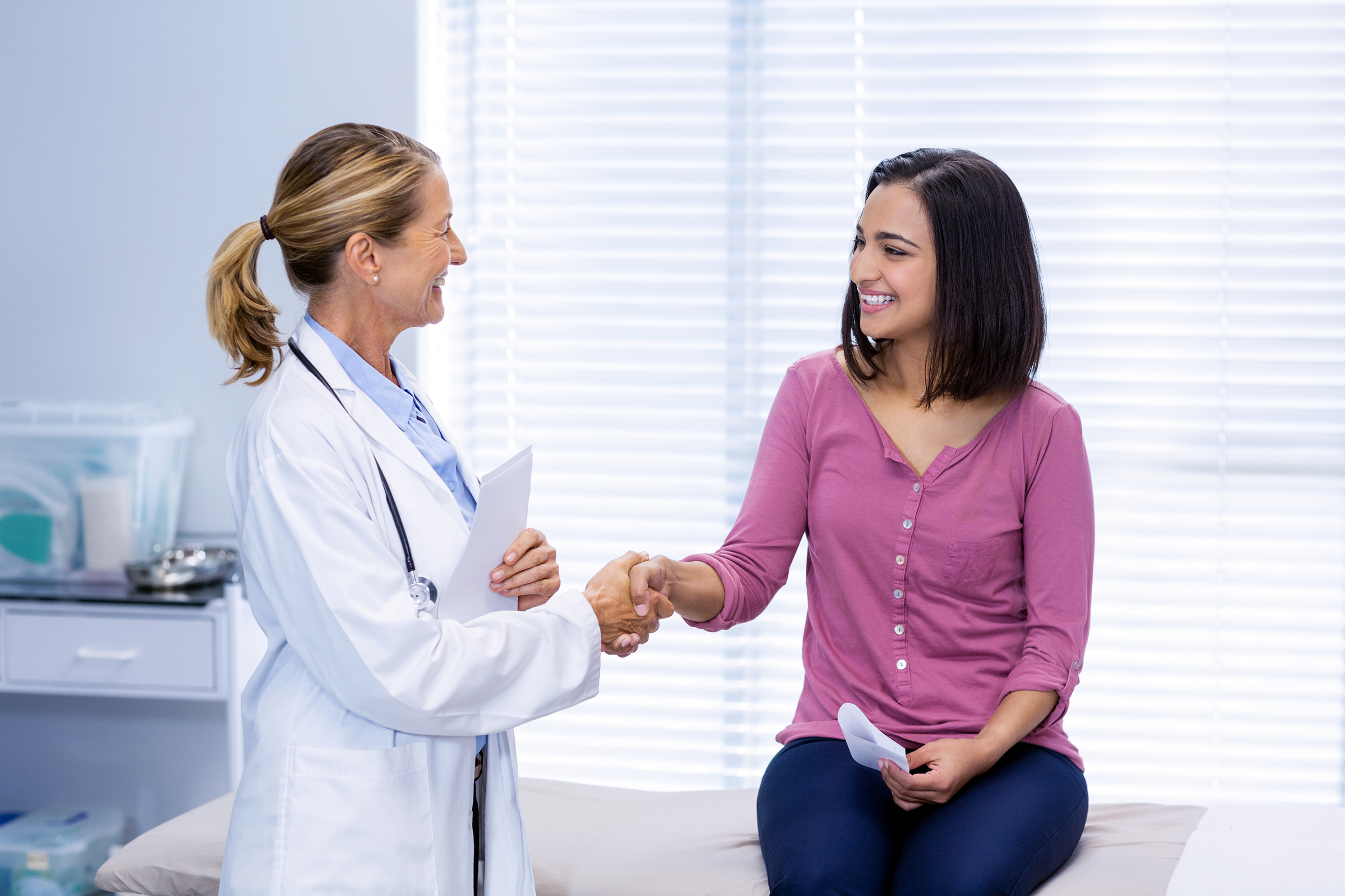 Woman shaking hands with the doctor during a check-up