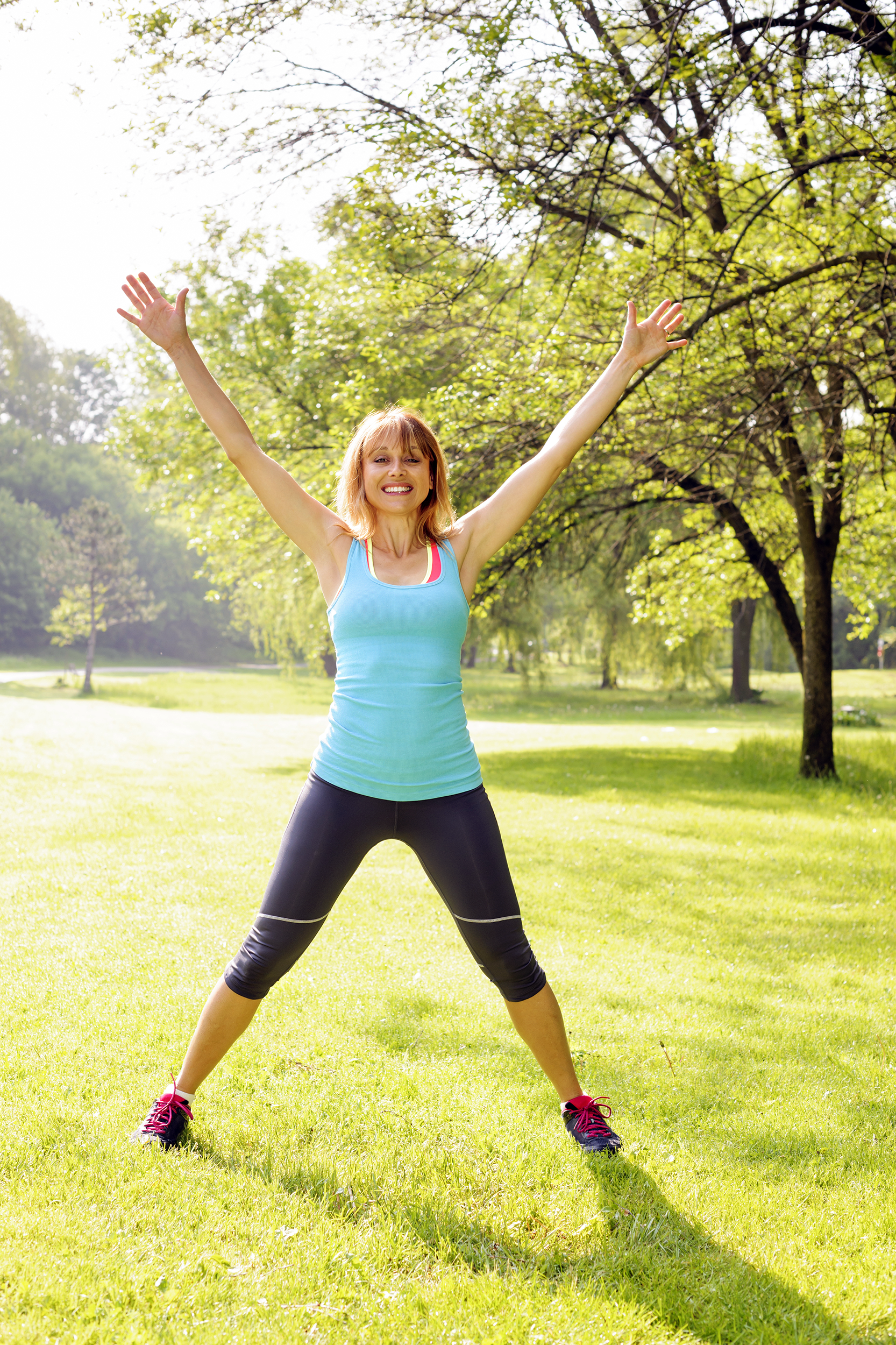 Woman doing jumping jacks outside