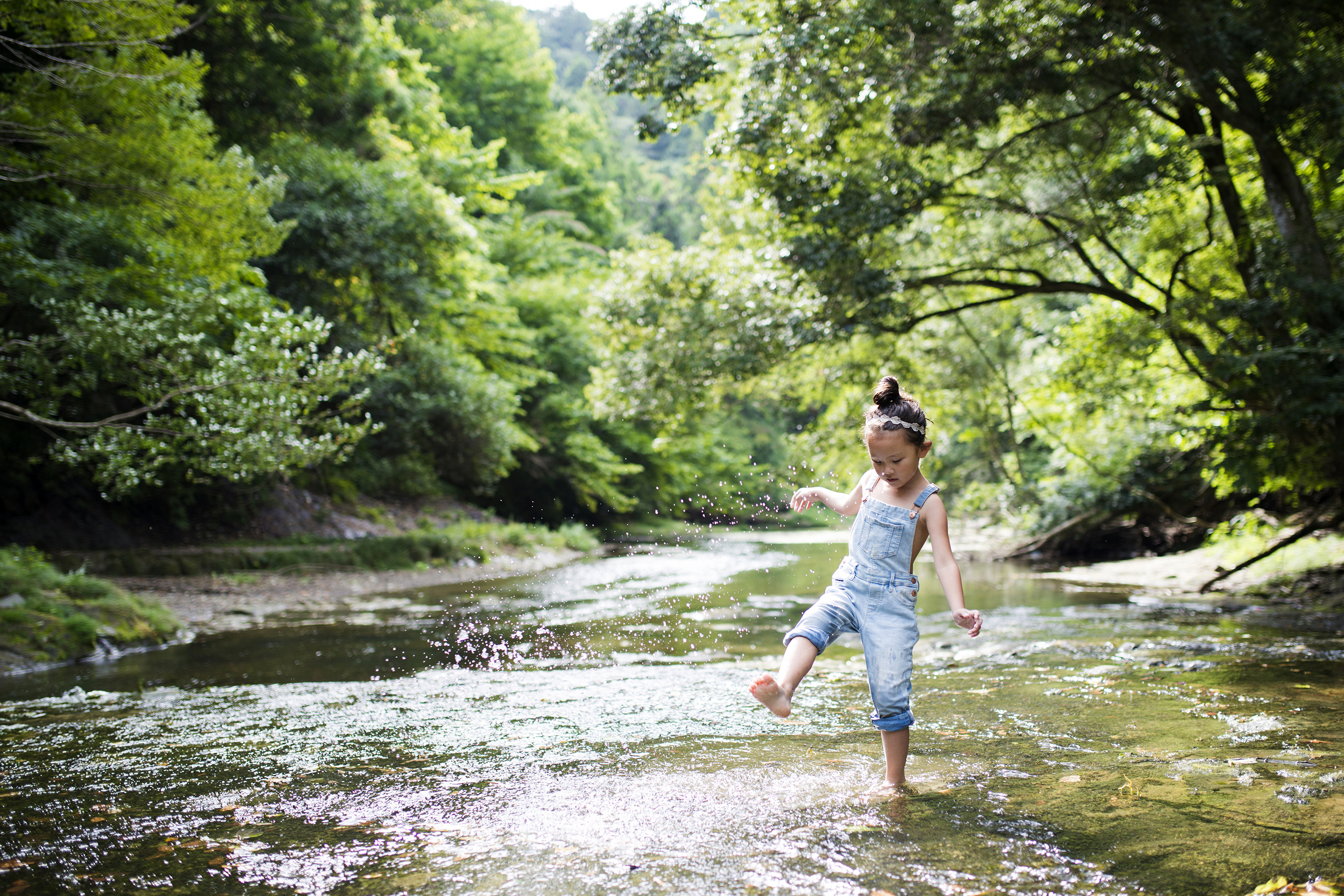 Little girl playing outside at the creek