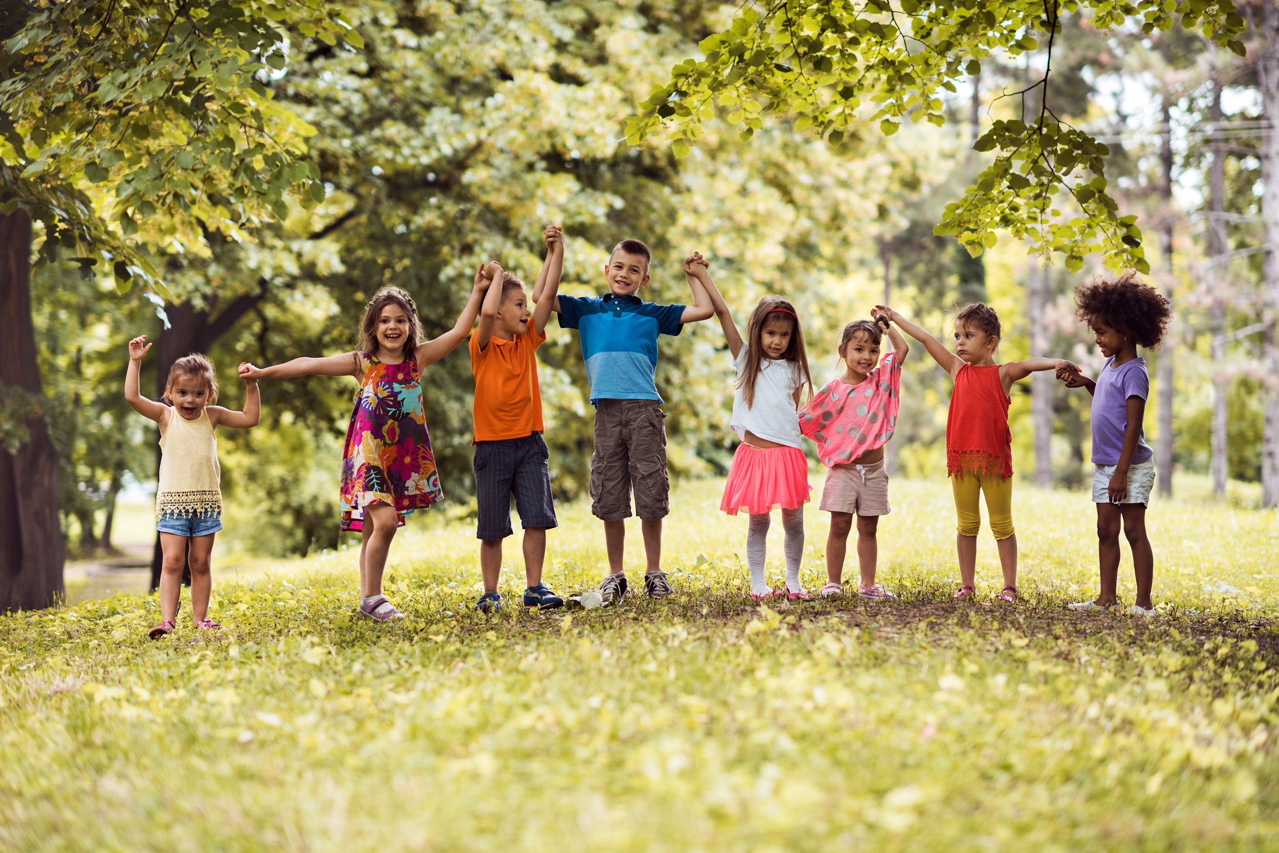Kids holding hands in a line outside
