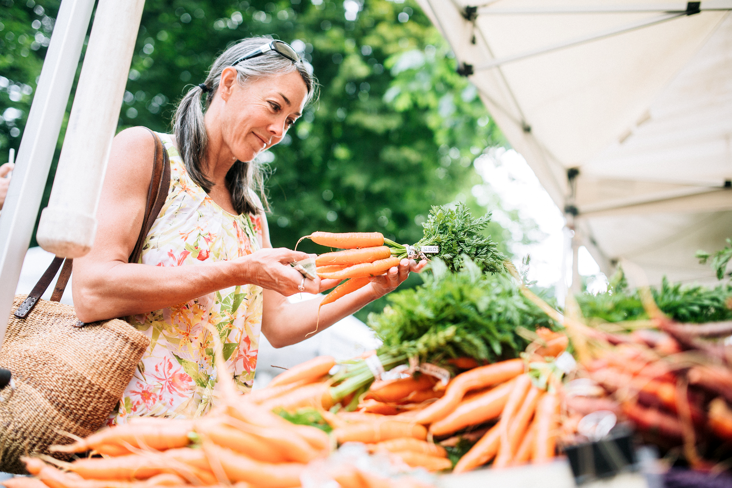 Woman looking at carrots at a farmers' market