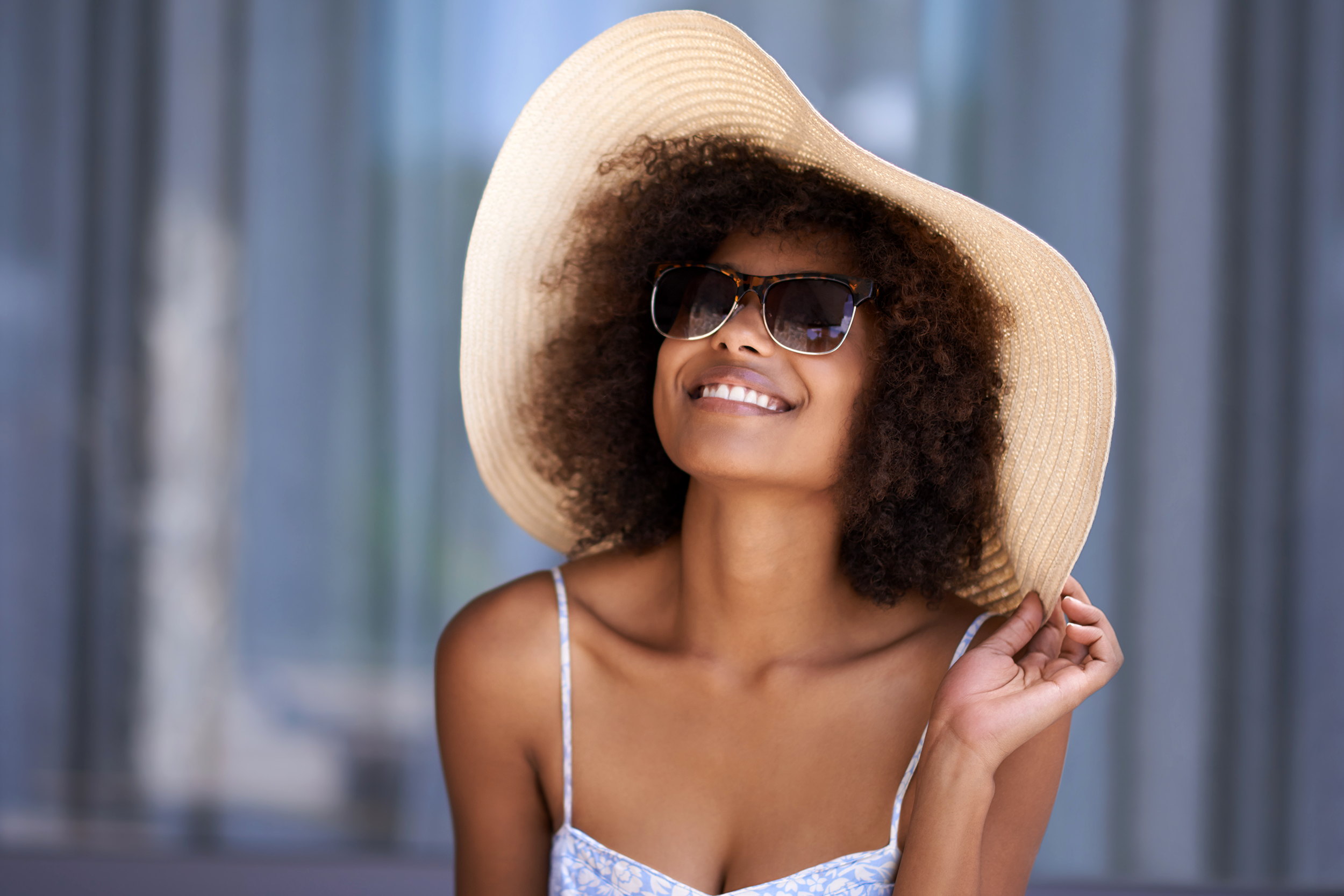 Woman wearing a large fashionable summer hat and sunglasses