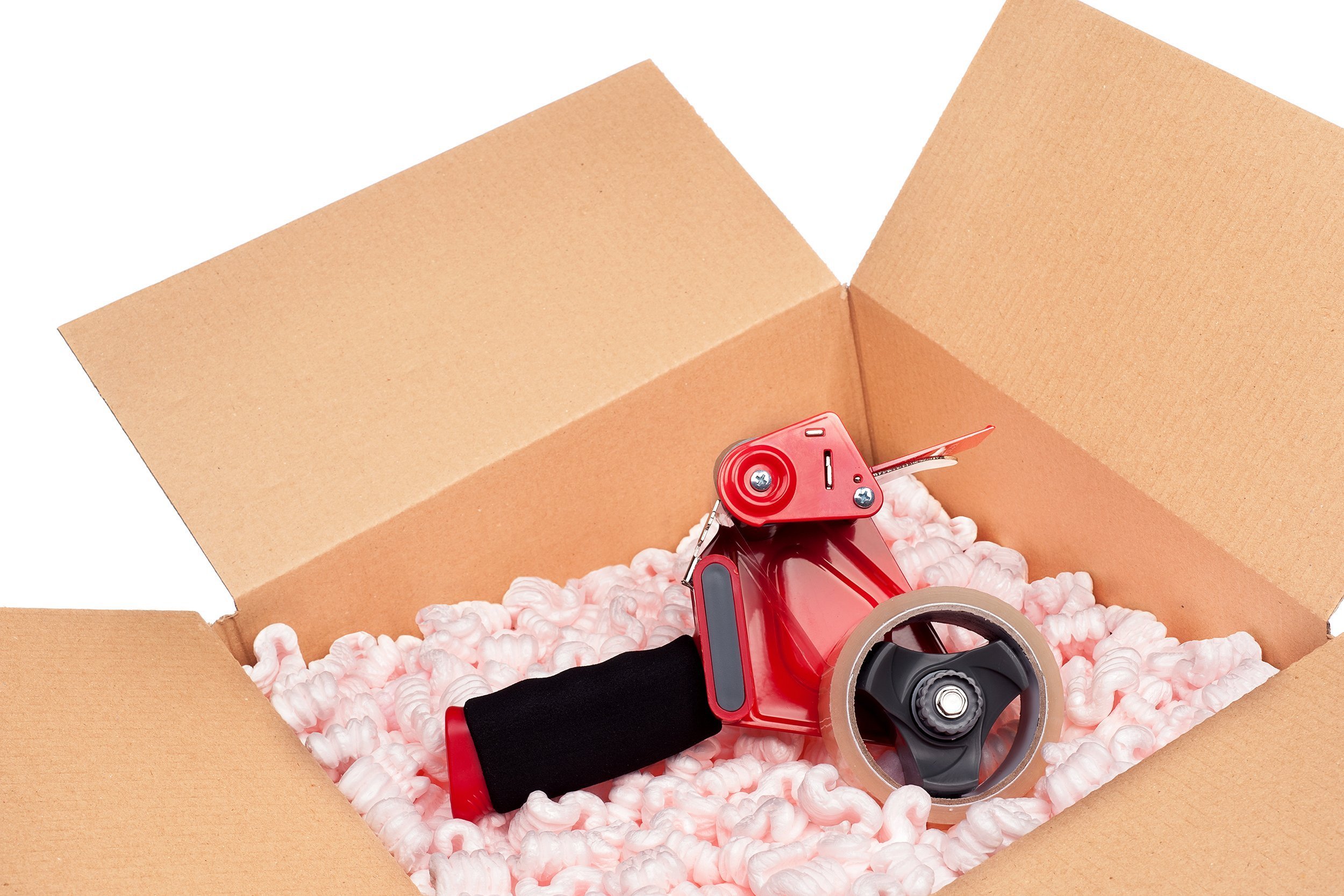 box full of protective packaging peanuts and a tape dispenser ready to be sealed up for shipping