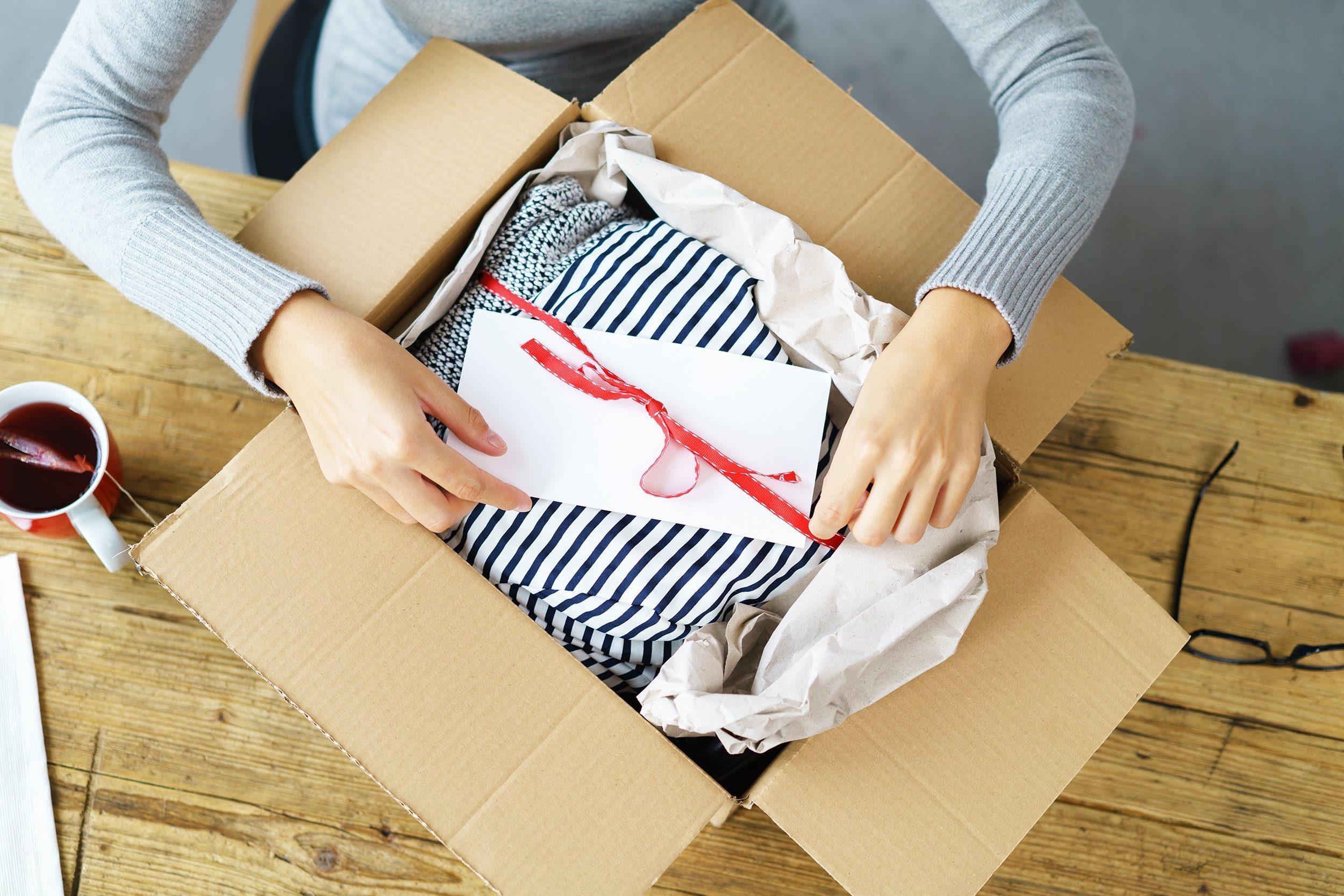 woman packaging clothes in shipping box