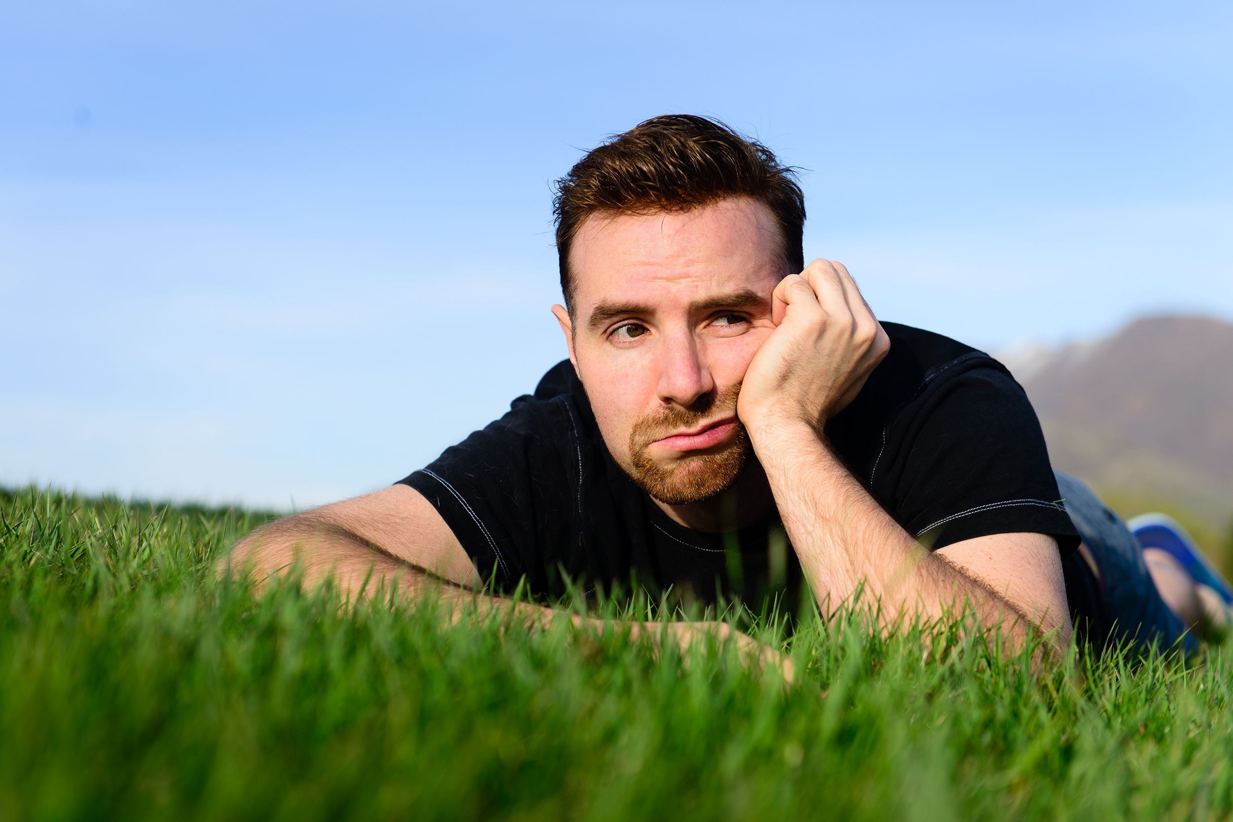 bored man laying on grass