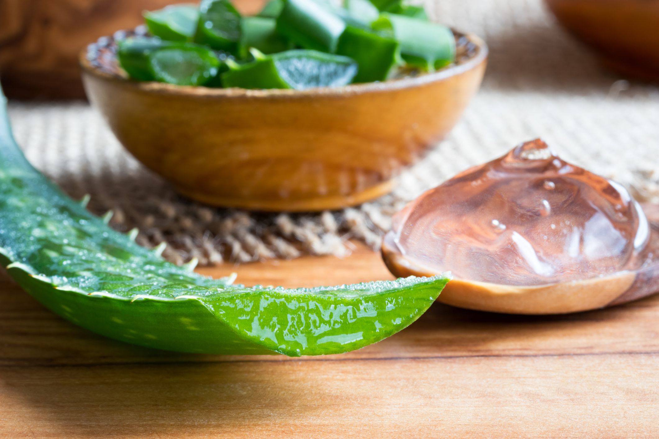 aloe vera plant slices and gel on wooden surface