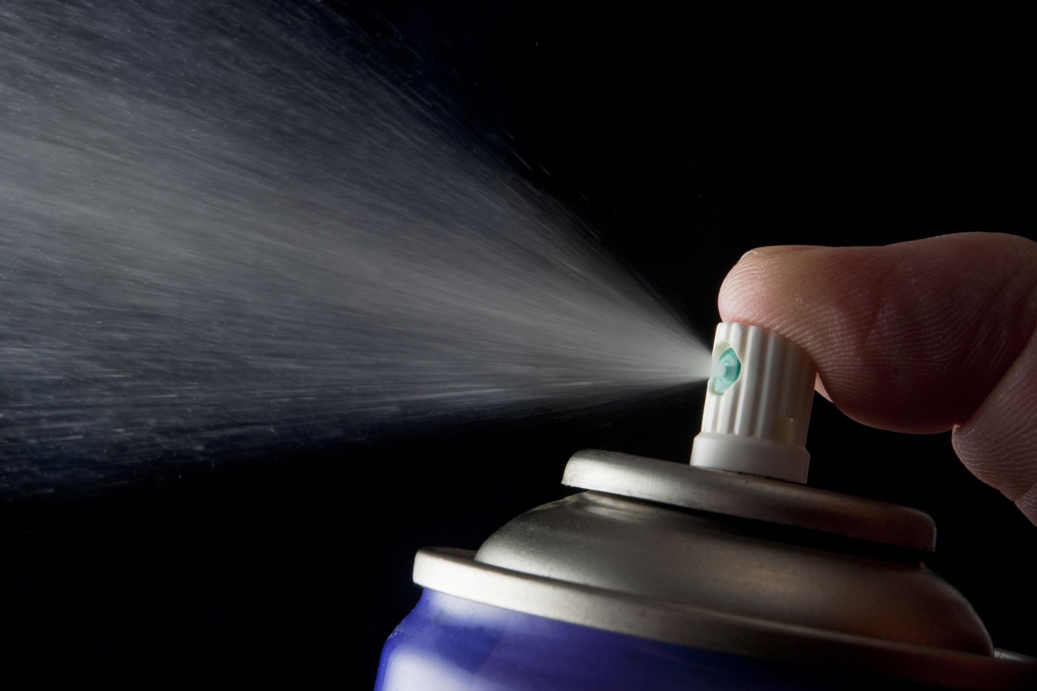 finger pressed spraying aerosol can