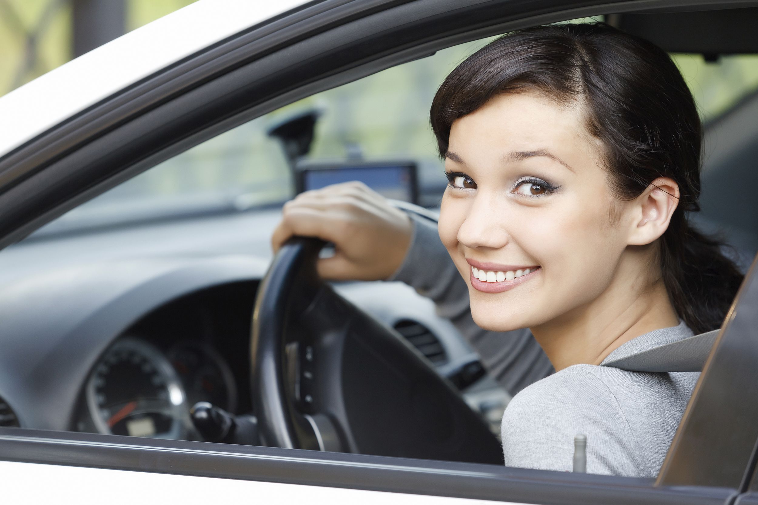 teen smiling out of window of car