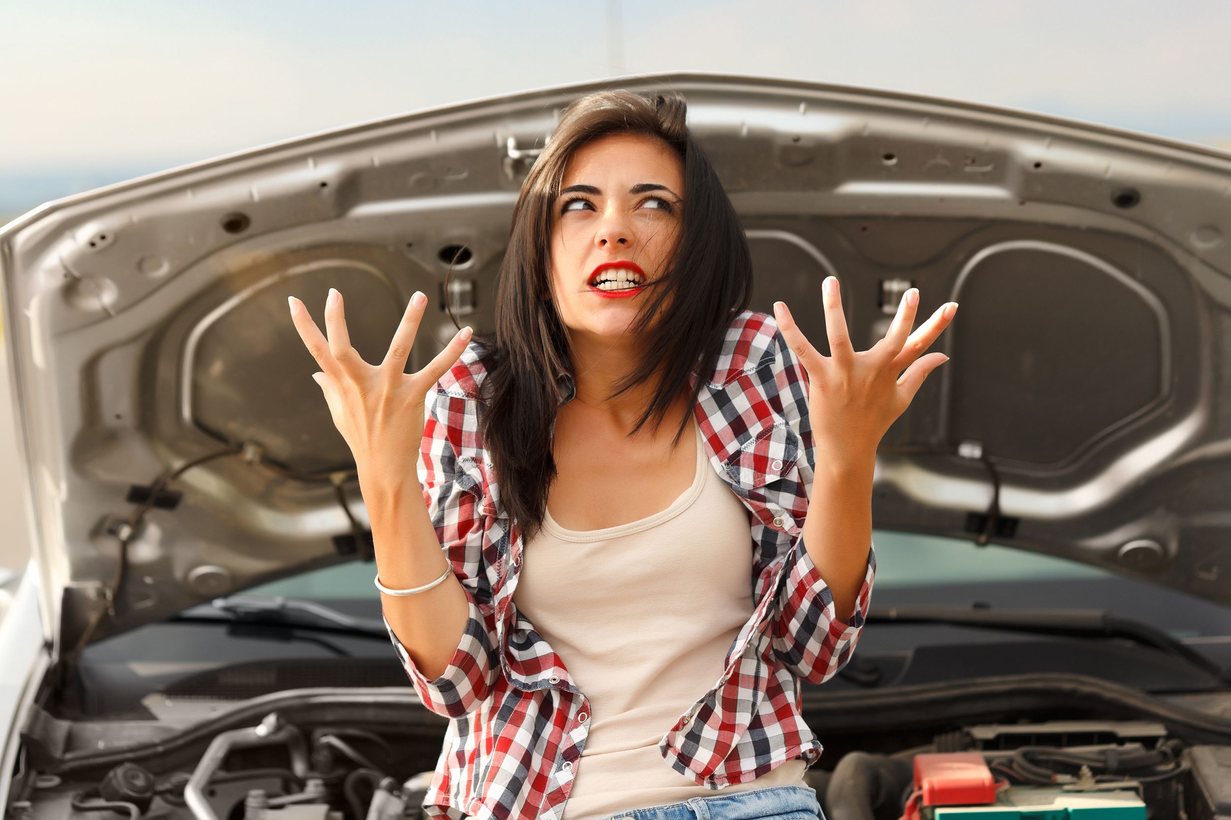angry woman in front of broken down car