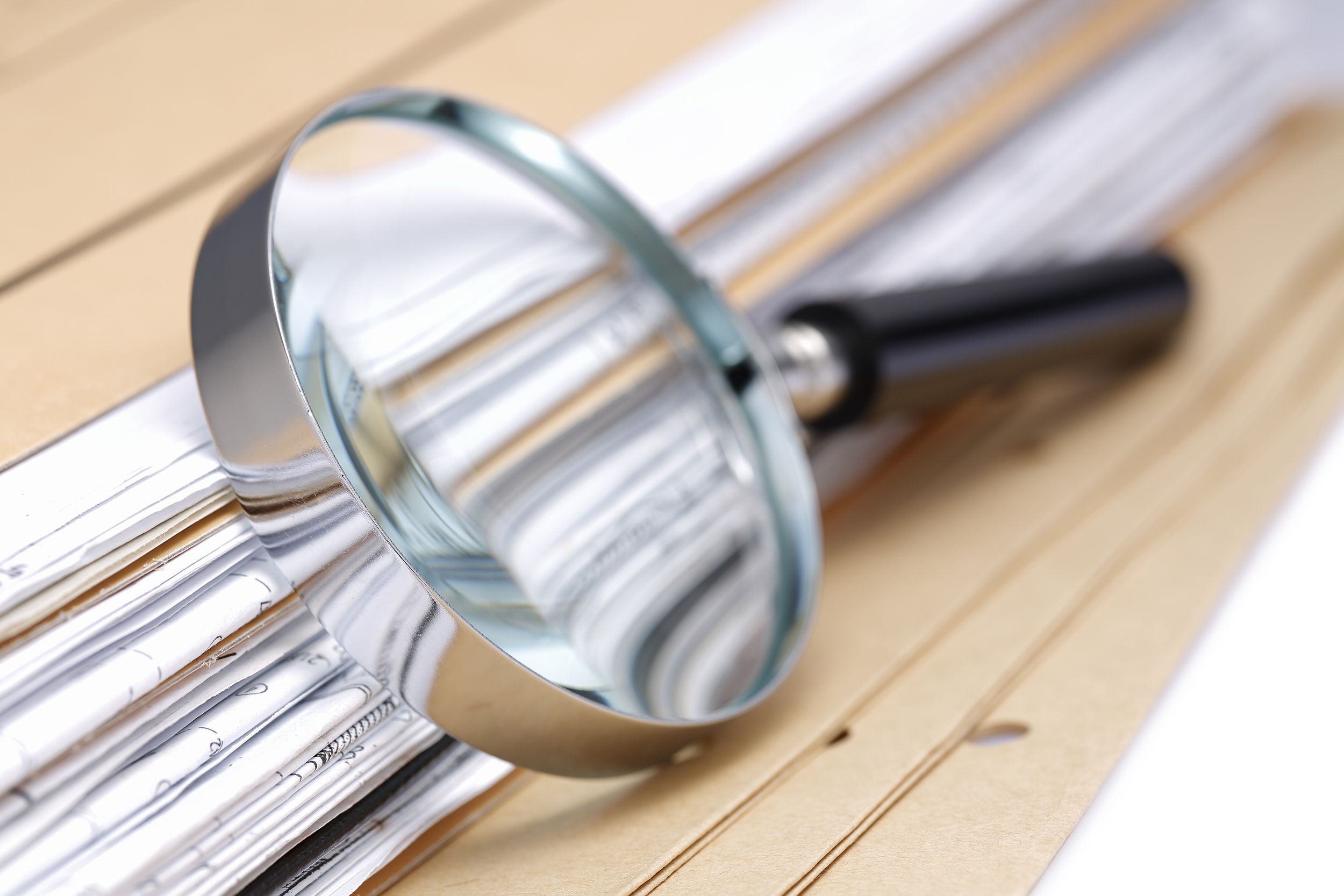 magnifying glass on folder of documents