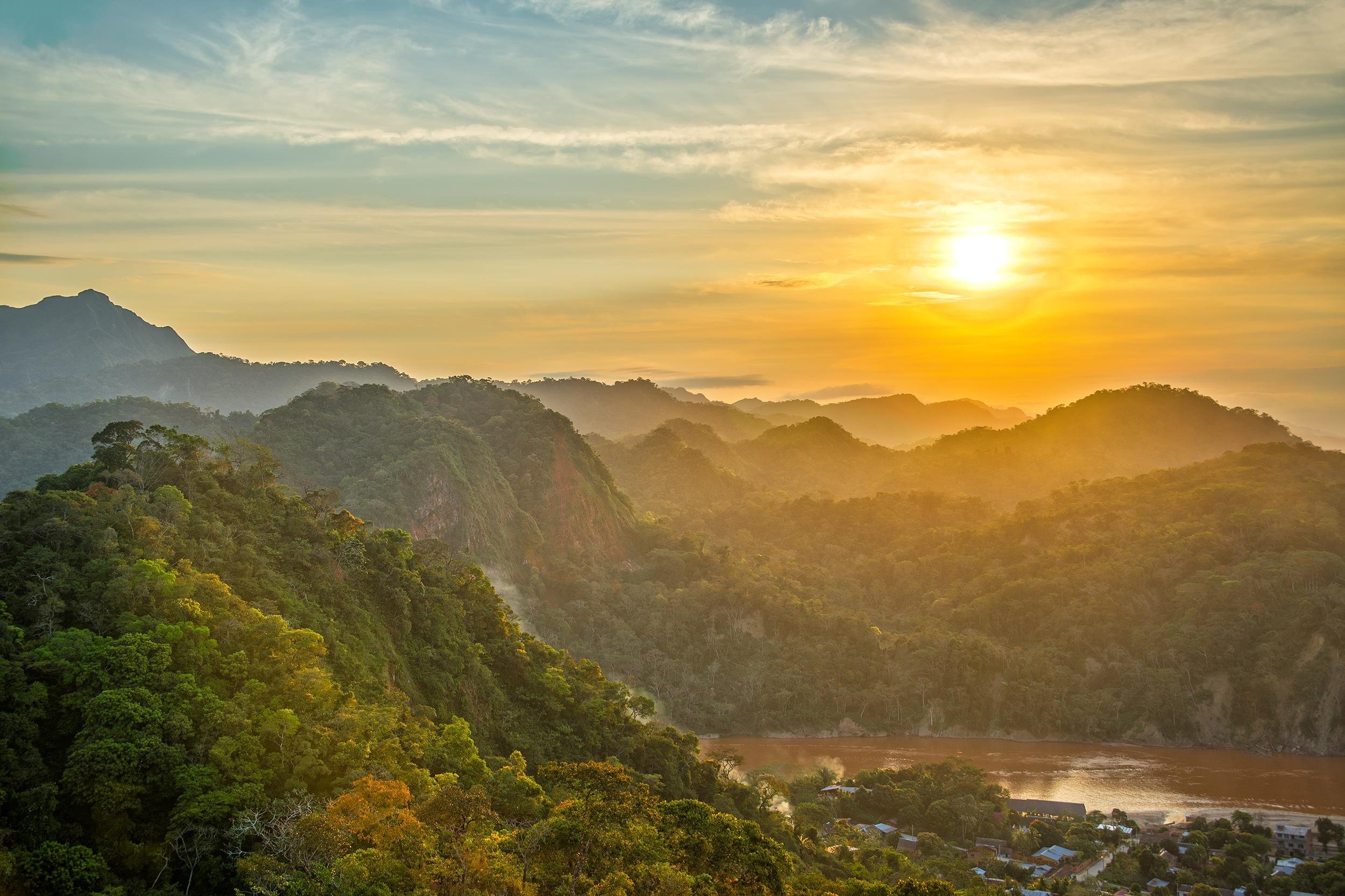 sunset over lush green jungle covered hills with the Beni River visible in Rurrenabaque, Bolivia
